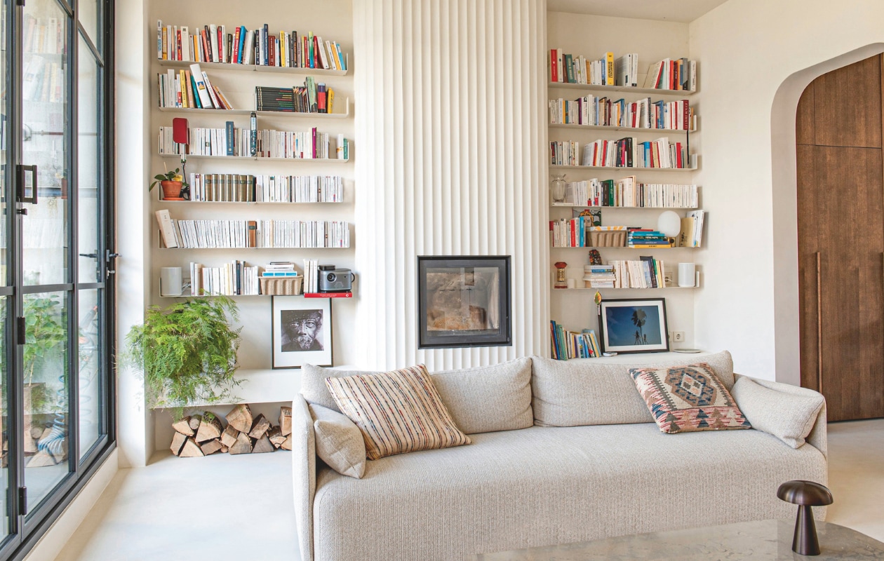 Boekenplanken Teebooks. Schouw Orac decor. Bank Offset van Audo. Kussens meegebracht uit Parijs. Tafellamp Como Sc53 van &Tradition. Rode lamp in boekenrek Apex van Hay. Witte lamp in boekenrek Jwda van Menu. Plafondspot Minude Jack van Modular. Gietvloer Tendenza. Wandkleur Stock 37 van Little Greene. vtwonen 10-2025 | fotografie Caroline Coehorst