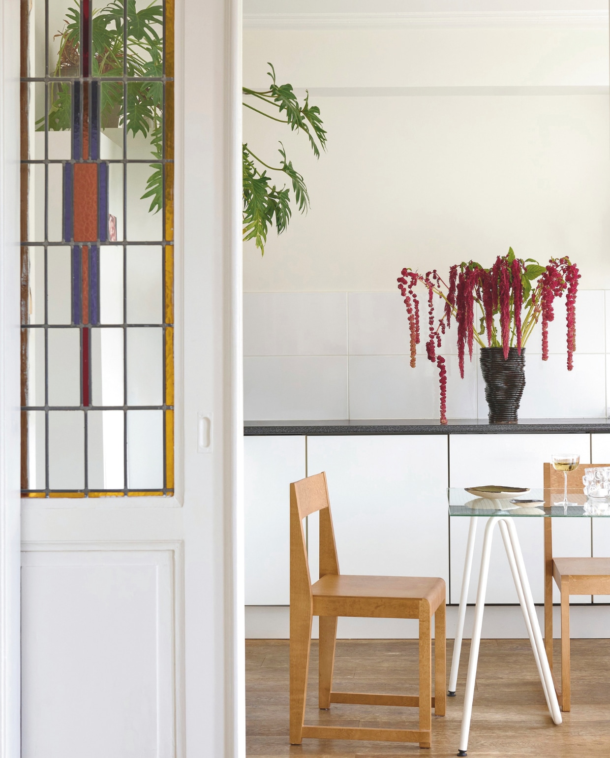 Het onderstel van de tafel vond Gloria online, ze liet er een glazen blad voor maken. Stoelen Frama. Vaas 2222Studio. Stijlvol wonen 9-2025 | styling Marianne Luning | fotografie Kasia Gatkowska | tekst Anneleen Peeters