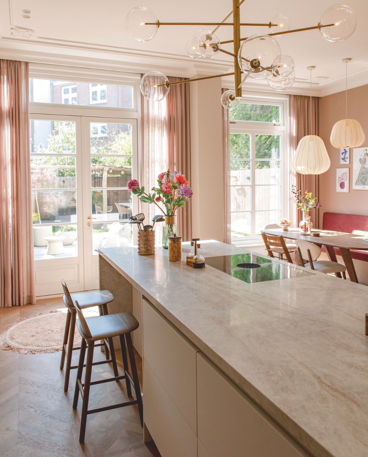 Plafondornamenten en sierlijsten Het Schippertje. Gordijnen Holland Haag. Eettafel Lopped Butik. Lampen erboven Bolia. Stoel TrippTrapp van Stokke. Eetkamerstoel Mobitec. Bank op maat gemaakt. Vaas Trendhopper. Kandelaars Xenos. Rond vloerkleed Tapis Petit. Tuinmeubels The Garden Store. Vaas op aanrecht Kare Design. Oliestel Zara Home. Kookplaat Bora. Pot Things I Like Things I Love. vtwonen 10-2025 | fotografie Caroline Coehorst