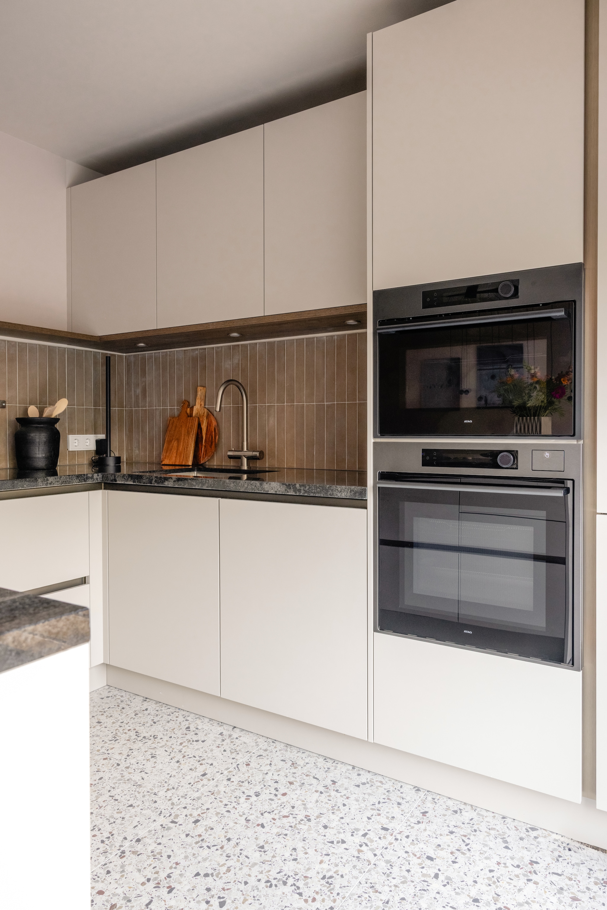 Muurverf Jewel no. 66 Lab Paint. Raambekleding in de kleur 9888 Tormes Luxaflex®. Keuken op maat inclusief apparatuur, met messing grepen, walnoten details en granieten werkblad Mandemakers. 5-in-1 oven Graphite CSX8695D, 60 cm (h), oven met stoom Graphite CS8495D, 45 cm (h), onderbouw wijnklimaatkast ConnectLife KU8574K2C, elevate inductiekookplaat met geïntegreerde afzuiging HIDD28472SVI, 83 cm (b), recirculatieset HR0016 Atag. vtwonen tegels by Douglas & Jones: Earth Argilla, 5x30 cm en vtwonen tegels by Douglas & Jones: Terrazzo Ice Flakes, 60x60 cm Douglas & Jones. Overige productinformatie via https://www.vtwonen.nl/weer-verliefd-op-je-huis/aflevering-6-fietje-hoofddorp-resultaat~bcad0e2.   vtwonen Weer verliefd op je huis aflevering 6 seizoen 23 2025 | styling Fietje Bruijn | fotografie Sonja Velda