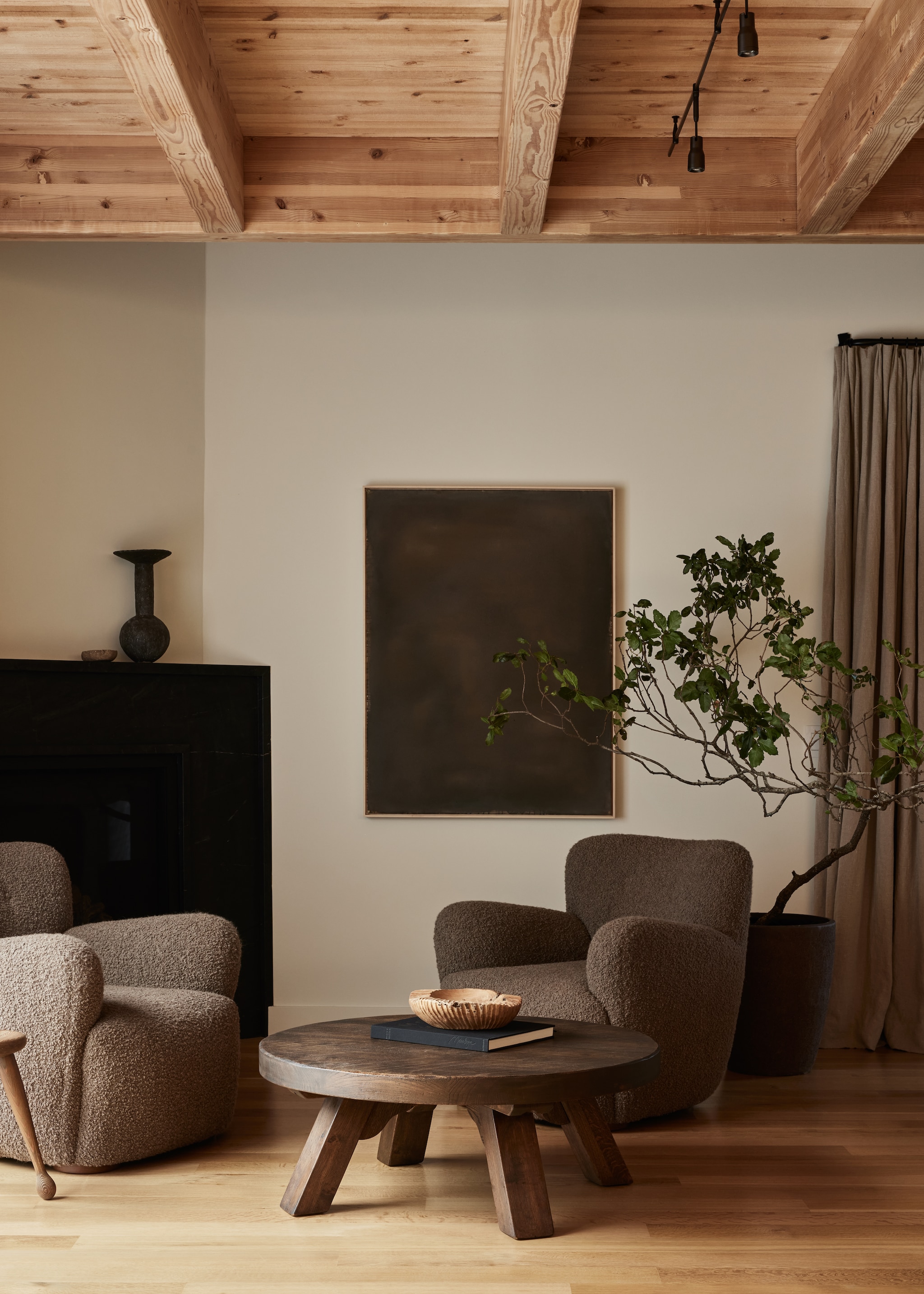 Loungestoelen Studio Giancarlo Valle, bekleding van Rogers & Goffigon. Antieke tafel Galerie Half. Kunstwerk Ali Enache. Haard bekleed met leisteen.  vtwonen Landelijk 01-2026 | styling Kendra Smoot | fotografie Nicole Franzen