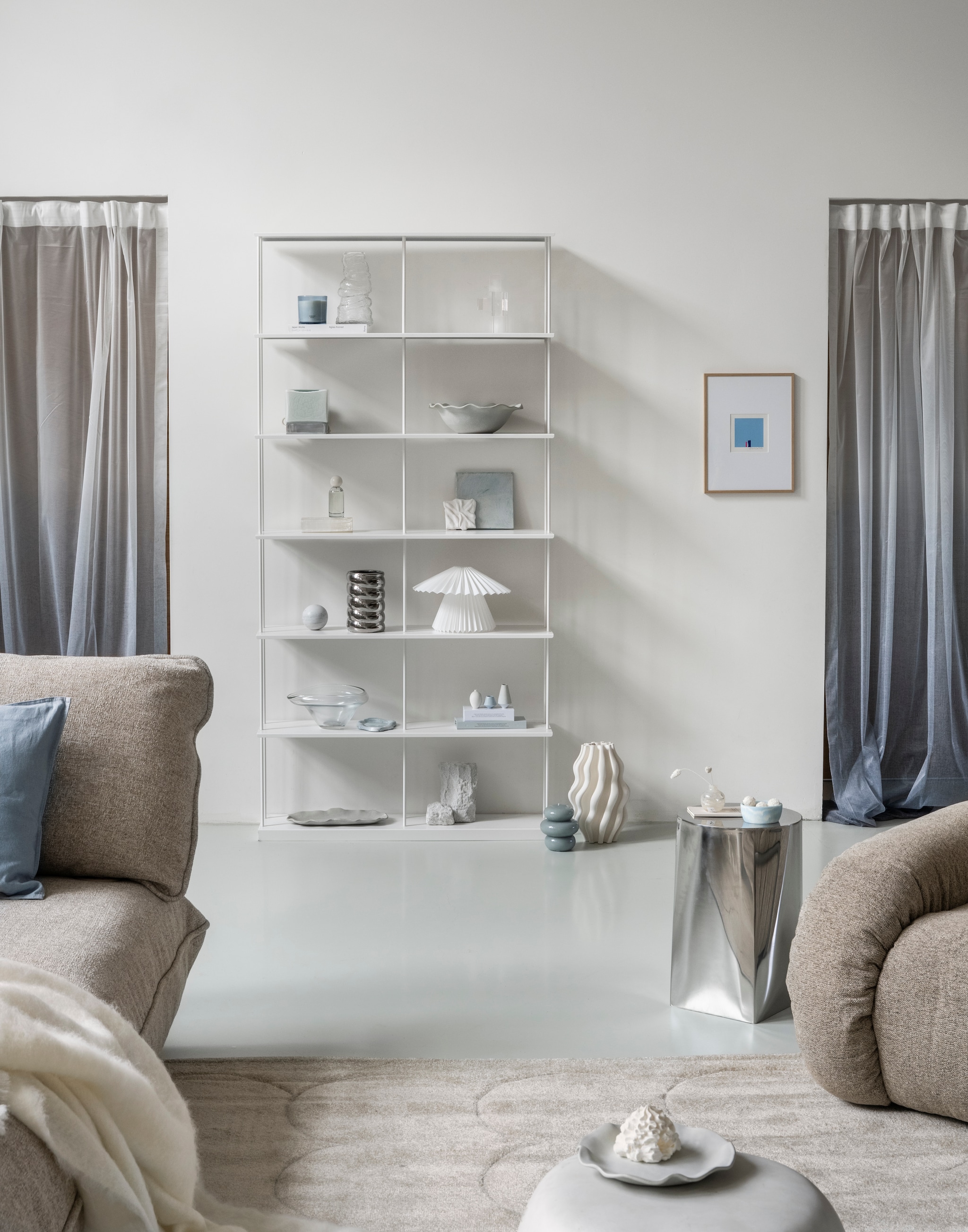 HKliving loungestoel Arc, verchroomd staal en polyester, sand, 101x98x74 cm (bxdxh) € 1650,-, vtwonen bijzettafel Pebble, betonlook, wit, 50x35 cm (Øxh) € 199,- (shop.vtwonen.nl). Fatboy bank Sumo, bouclé, beige, 301x108x90 cm (bxdxh) € 3999,-, vloerkleed Bubble carpet, stof, vanilla ice, 290x200 cm (lxb) € 499,- (fatboy.com). HKliving schaaltje Patio, pale blue € 16,95 (hkliving.com). Karwei vaas, keramiek, wit, 3D-geprint € 59,99 (karwei.nl). H&m Home bordje, terracotta, wit € 24,99, kussenhoes, linnenmix, dusty blauw € 9,99, asymmetrische schaal, glas, transparant € 29,99, grote schaal, terracotta met geschulpte rand, wit € 39,99, grote ovale schaal, terracotta, wit € 49,99, vaas, glas, lichtgeel € 4,99 (hm.com). Zara Home bijzettafel, roestvrij staal, zilver € 159,-, deken, wol, ecru € 149,-, geurkaars Vibrant rose, blush grey, 400 g € 22,99, kubusvormige tafellamp, glas, zilver€ 59,99, spray diffuser Éclat de lys, blauw, 100 ml € 15,99, kaars, decoratief golvend, blauw € 22,99 (zarahome.com). Ikea tafellamp Kuddlava, geplisseerd, kunststof, wit28 cm (Ø) € 9,99 (ikea.nl). Bergkristal, wit, 20x10x5 cm (lxbxh), prijs op aanvraag (ananda.nl). Schilderij, 3D, wit 10x10 cm (lxb), prijs op aanvraag (sanneketelaar.com). Kwantum vaas Cagnola, glas, transparant € 7,- (kwantum.nl). Trendcarpet gordijn Linda, kunststof, wit-grijs, 140x260 cm (bxh) € 39,99 (trendcarpet.nl). Overig privébezit. vtwonen 01-2026 | styling Sanne Ketelaar | fotografie Stan Koolen