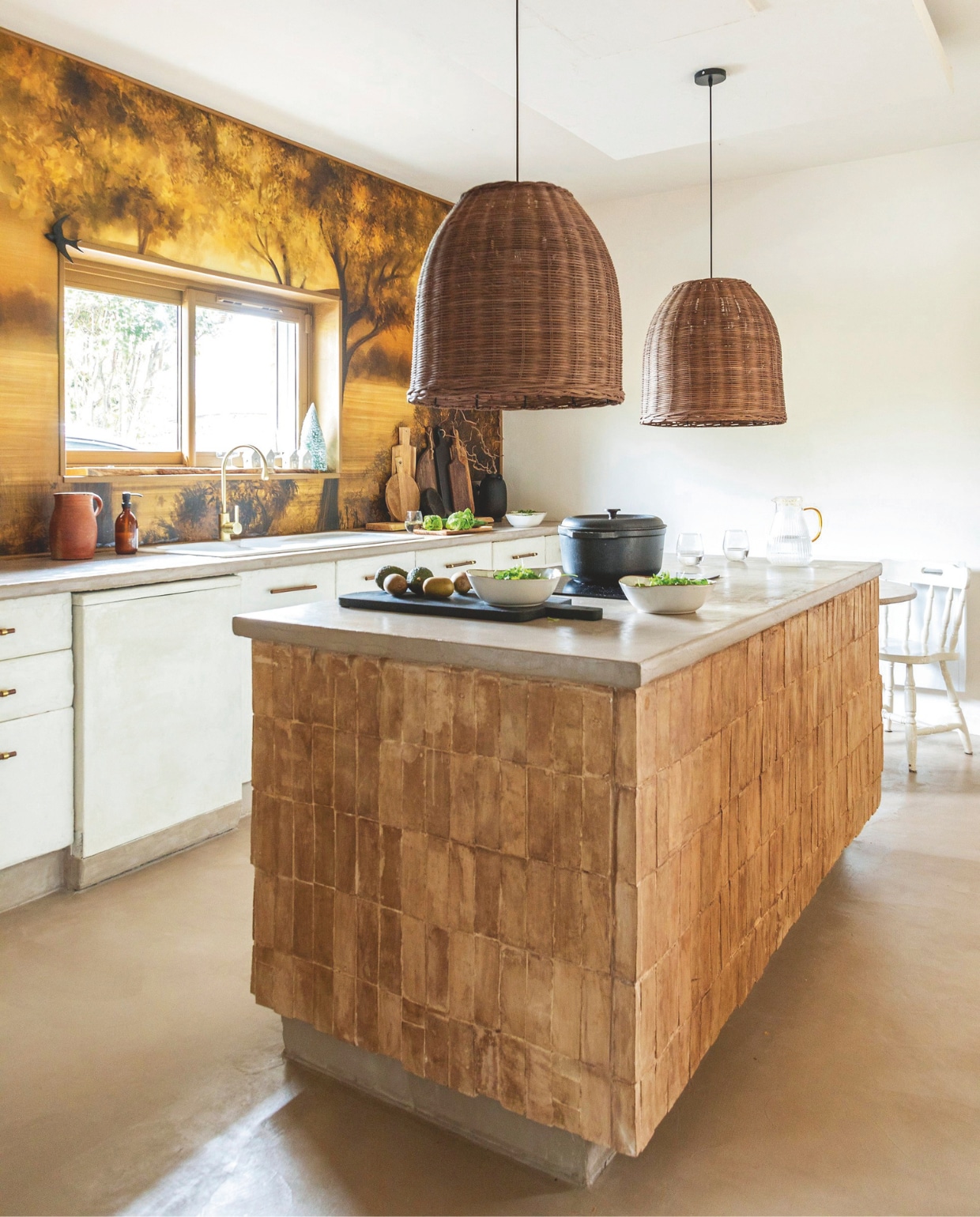 Behang Maison Deco. Hanglampen Las Sola. Werkblad en vloer Maison Étanche. Kraan 123Bain. Keukeneiland betegeld met bejmat tegels van Maison Zellige. Zwarte snijplanken Floraux. Stoofpan Le Creuset. Karaf L’Incroyable. Glazen Maxi Bazar. Schalen Alinea. vtwonen Landelijk kerstspecial 2025 | styling Marie-Maud Levron | fotografie Cecile Perrinet Lhermitte | tekstbewerking Britte Kramer