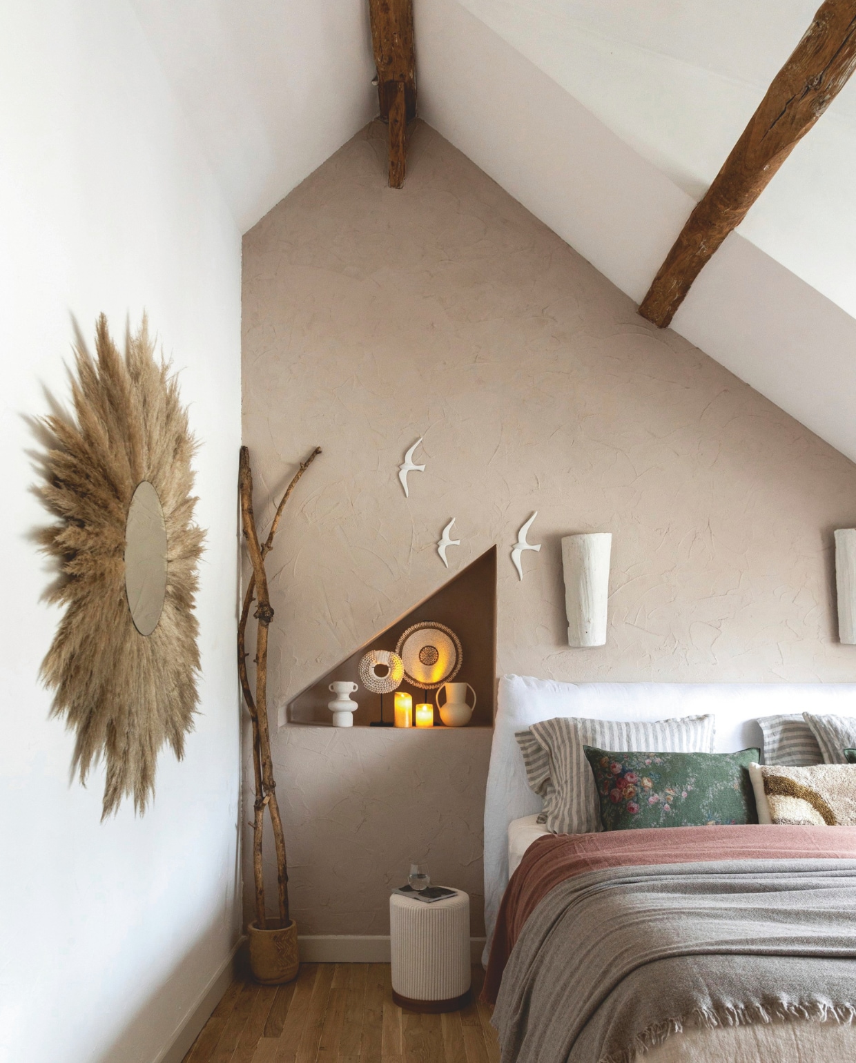 Kalkverf achter het bed Noce van Kalklitir. Muurverf andere muren White Velvet van V33. Wandlampen van oude dakpannen, gemaakt door Eve. Spiegel met gevonden pluimen, gemaakt door Eve. Poef en vazen L’Incroyable. Keramieken zwaluwen Leboncoin. Beddengoed Maison de Vacances. Kussenhoezen Le Monde Sauvage. vtwonen Landelijk kerstspecial 2025 | styling Marie-Maud Levron | fotografie Cecile Perrinet Lhermitte | tekstbewerking Britte Kramer