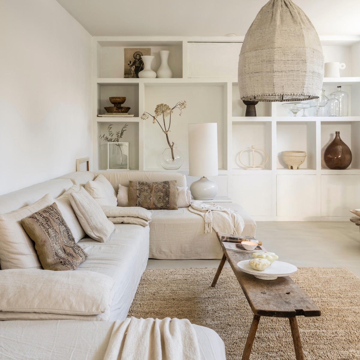 Linnen bank L’Authentique. Gekleurde kussens uit Marrakech. Witte pompoenen en kom Atelier November.  Vintage slagerstafel.  Hanglamp Mo’s Interior Art. Taartschaal @voc2012. Kast op maat gemaakt, geschilderd met stuccoverf van L’Authentique. Tafellamp Kwantum. Vloerkleed Pomax. vtwonen Landelijk 10-2025 | styling Marianne Luning | fotografie Stan Koolen