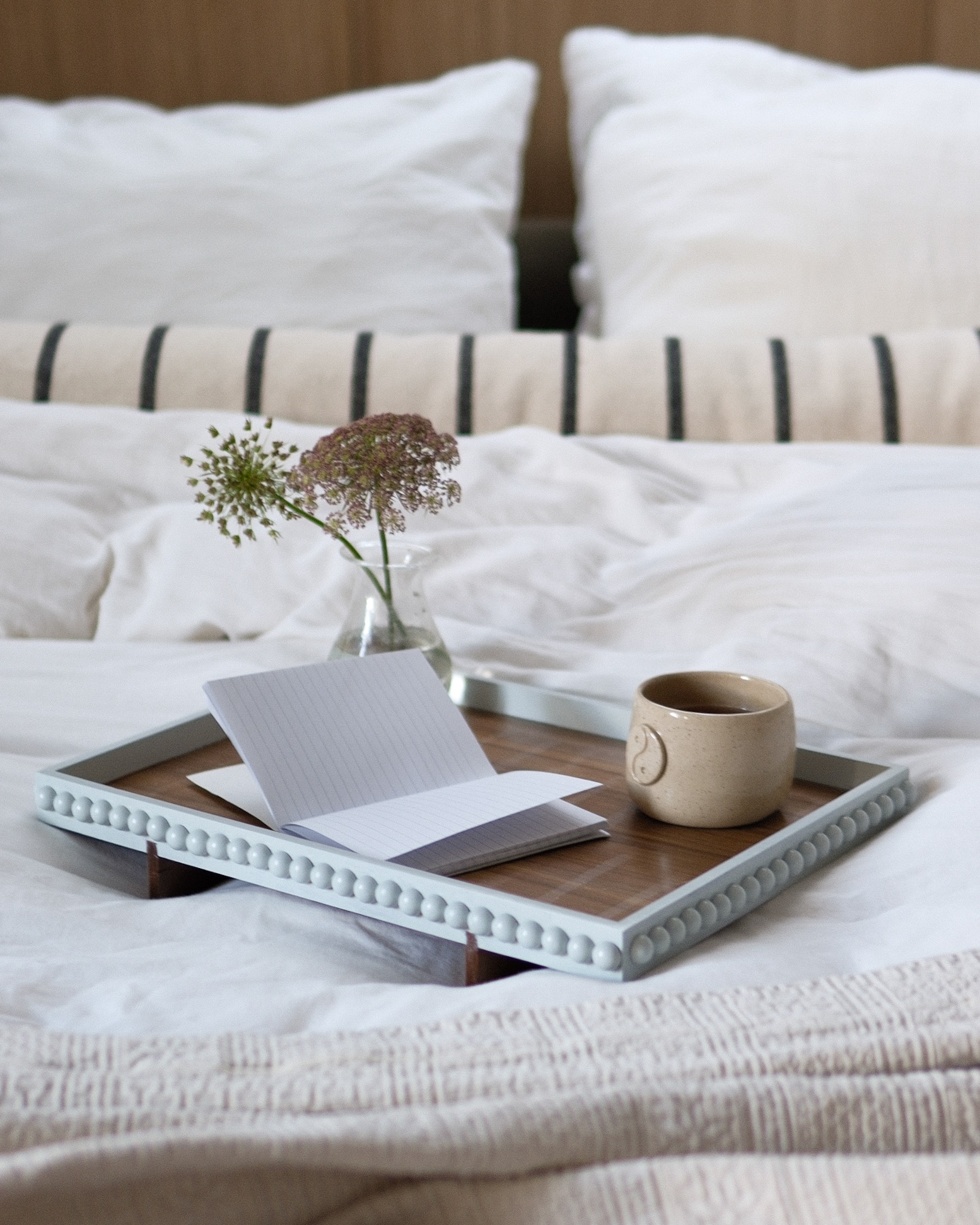 Bredemeijer dienblad Wazuka via shop.vtwonen.nl. Mok Putzy Ceramics. Beddengoed Yumeko. Gestreept bolsterkussen zelf gemaakt. Vaas en sprei tweedehands. vtwonen 01-2026 | styling & fotografie Valerie Paas