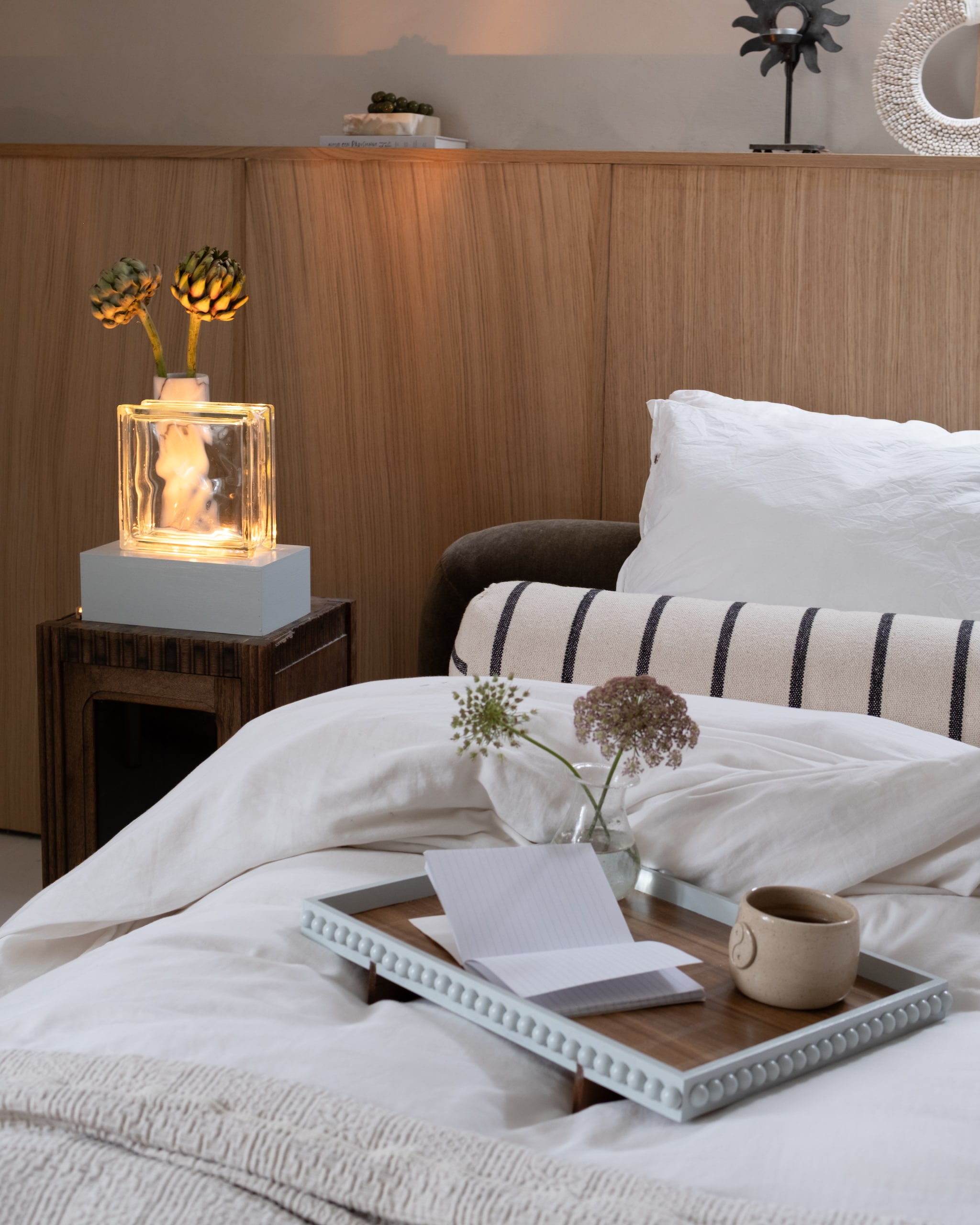 Bed Jotex. Gestreept bolsterkussen zelf gemaakt. Beddengoed Yumeko. Nachtkastje, marmeren vaas en waxinelichthouder tweedehands.