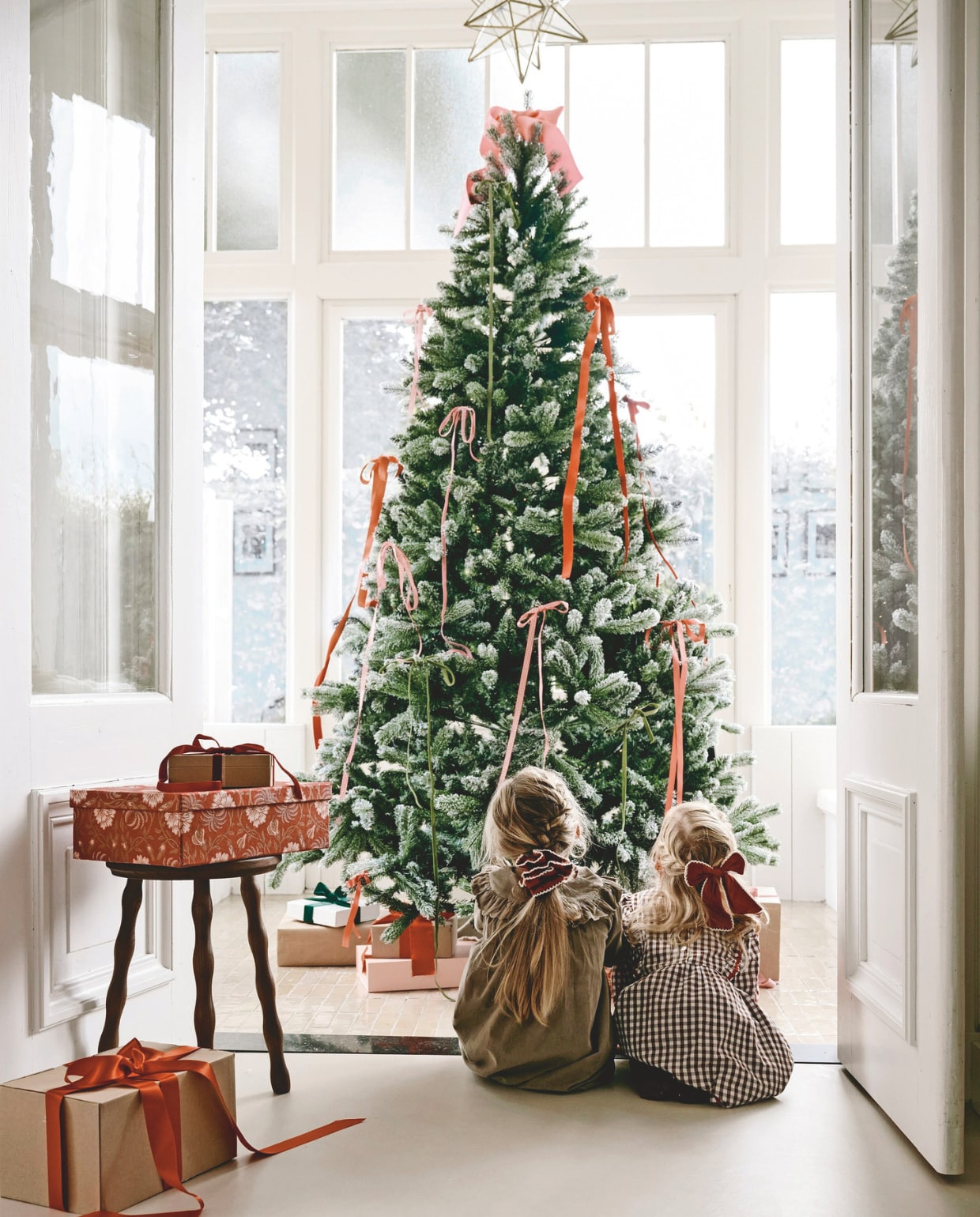 Zara Home kruk, hout, donkerbruin € 79,99 (zarahome.com). Leuk Verpakt inpakpapier denneboom, per rol € 3,25 (leukverpakt.nl). Bungalow opbergdozen, rood/roze, set van 2 € 53,75 (bungalow.dk). Søstrene grene opbergdoos, roze € 4,18 (sostrenegrene.com). Overig privébezit. Kleding Saar (jongste dochter): Sissel edelbo jurk (sissel-edelbo.com). Kleding Phie (oudste dochter): Marmar copenhagen jurk (marmarcopenhagen.com). vtwonen kerstspecial 2025 | styling Danielle Verheul | fotografie Sjoerd Eickmans