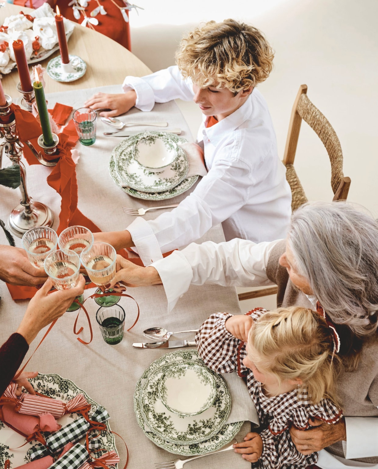 Firma Hout en Staal eettafel, eikenhout, 250x110x76 cm (lxbxh), vanaf € 1728,-, poef, rood € 250,- (loods5.nl). Zara Home stoelen, hout, per stuk € 189,-, servies, porselein, groen, per stuk vanaf € 6,99, waterglazen € 3,99, wijnglazen € 3,99, tafelkleed, linnen € 69,99 (zarahome.com). Polspotten eetkamerstoelen Cosy, forest green, per stuk € 400,- (polspotten.com). Kulu Club servetten, linnen met geborduurde strik, set van 2 € 23,95 (shop.vtwonen.nl). Tableware Amsterdam bestek, antiek, zilver, per couvert € 45,-, kandelaar, verzilverd € 75,- (tableware.amsterdam). Kleding Charlie (zoon): Zara blouse, shirt (zara.com). Kleding Willemijn (oma): Massimo Dutti rok, blouse, spencer (massimodutti.com). Kleding Saar (jongste dochter): Sissel Edelbo jurk (sissel-edelbo.com). vtwonen kerstspecial 2025 | styling Danielle Verheul | fotografie Sjoerd Eickmans
