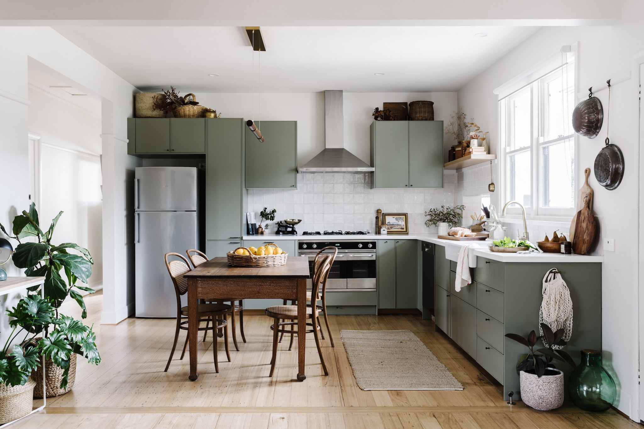 Keuken Ikea, geverfd in kleur Paris Creek van Dulux. De achterwand is bekleed met zelliges-tegels. Tafel tweedehands vondst.  Bentwood-stoelen via Facebook Marketplace. vtwonen Landelijk 02-2026 | fotografie Marnie Hawson | productie Living Inside