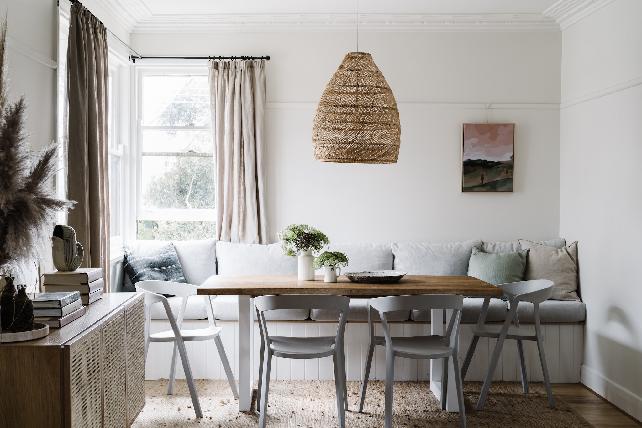 Zitbank maatwerk met Warwick-stof. Soortgelijke stoelen Cottage Furnishings. Soortgelijke eettafel Flexfurn. Hanglamp Freedom, soortgelijke Temple & Webster. Kunstwerk Rolling Hills van Rachel Stevens. Keramische kom is lokaal vervaardigd. vtwonen Landelijk 02-2026 | fotografie Marnie Hawson | productie Living Inside