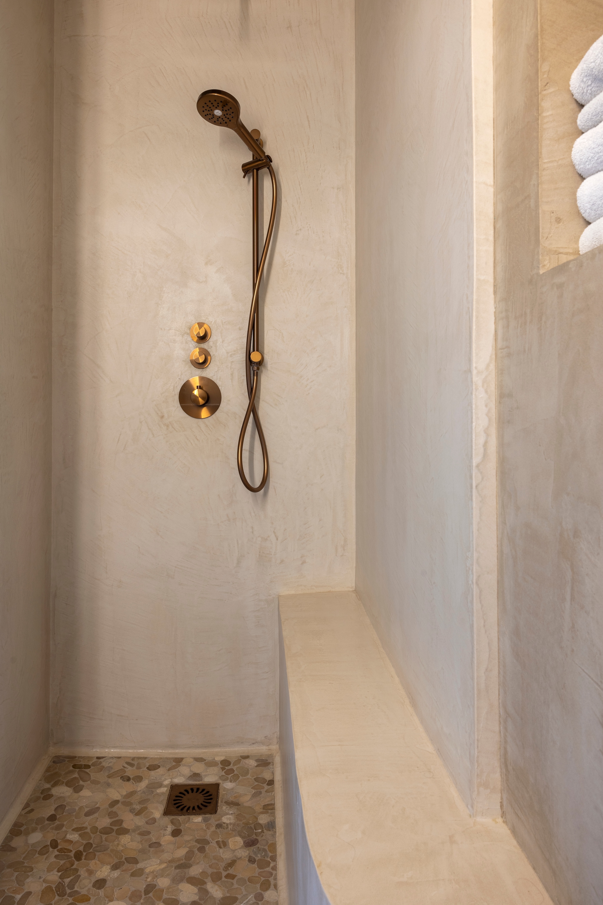 Douchekraan Brauer. Wand- en vloerafwerking beton ciré. Vloertegels kiezels ingewassen met beton ciré via Zv Wonen. vtwonen Landelijk 02-2026 | fotografie Anneke Gambon