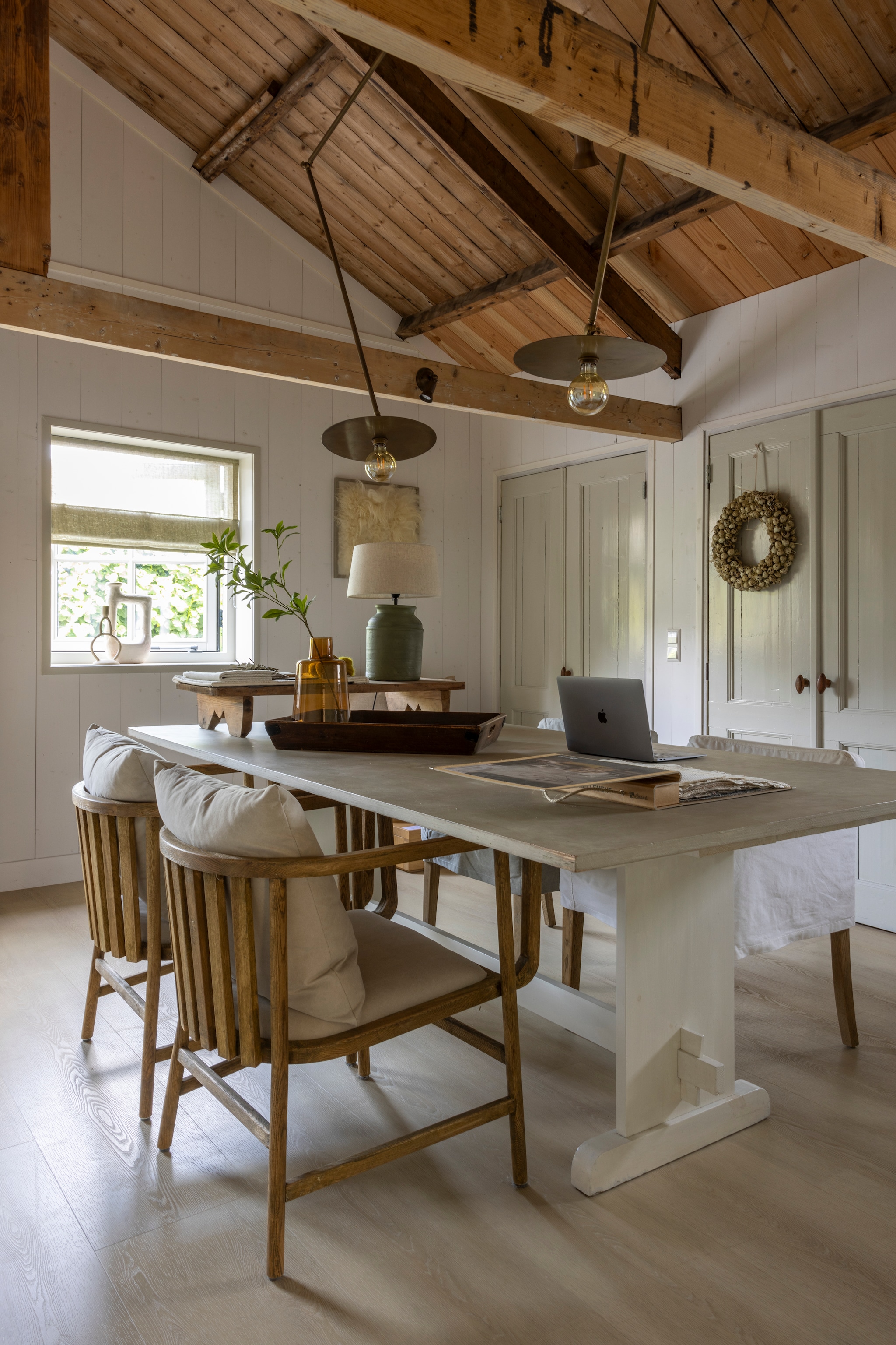 Tafel Timzowood, met eigengemaakt blad, afgewerkt met stucco. Vouwgordijnen Designs of the Time via Zv Wonen. Stoelen Leeff. Hanglampen Zv Wonen. Aardewerken lampvoet en kap Frezoli Lighting. Kruik en vaas Frans brocante. Houten tray op tafel Netty de Groot. Dienblad kringloop. Kunst aan de muur Zilt & Zacht. Vloer pvc Wide Board vtwonen. Muurkleur Krijt, kleur bedsteedeuren Muis van l’Authentique. vtwonen Landelijk 02-2026 | fotografie Anneke Gambon