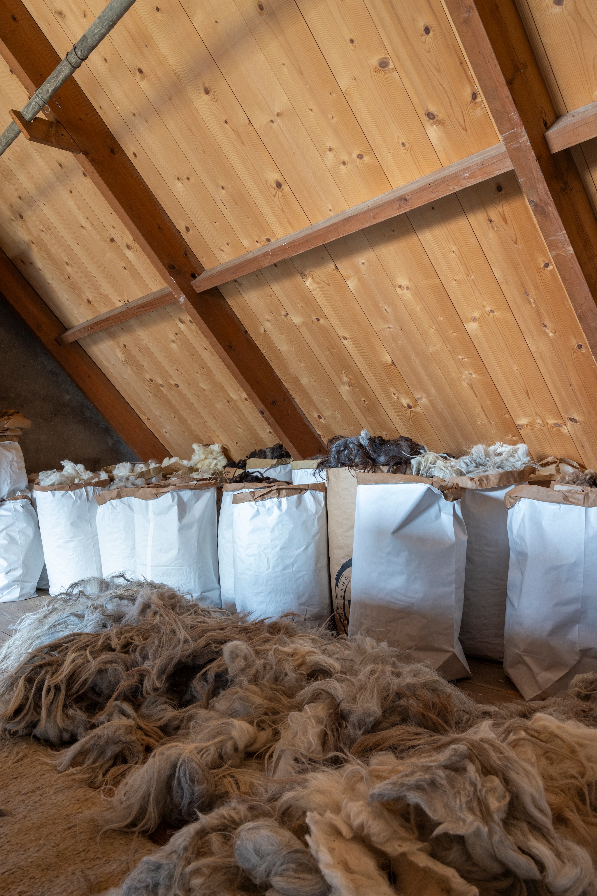 De wolzolder, waar Loesanne de wol voor haar workshops bewaart. De wol komt van lokale zeedijk-schapen en uit Groningen en Drenthe. Alle wol wordt door Loesanne gewassen met regenwater. vtwonen Landelijk 02-2026 | fotografie Anneke Gambon