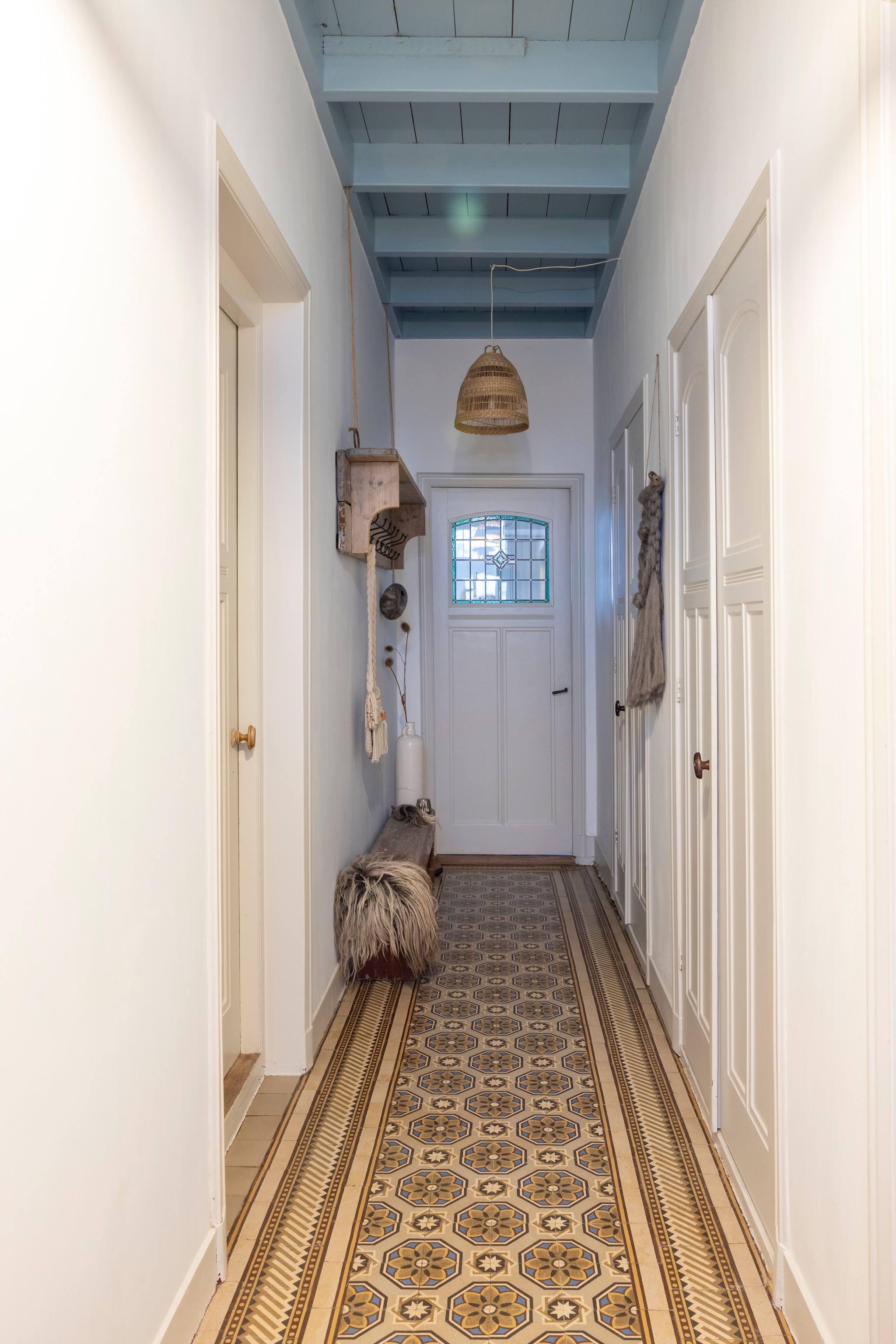 Hal met originele tegelvloer. Plafondkleur Porcelain van Painting the Past. Kleur bedsteedeuren Ammonite van Farrow & Ball. Hanglamp Ikea. Wanddecoratie WenKR8. vtwonen Landelijk 02-2026 | fotografie Anneke Gambon