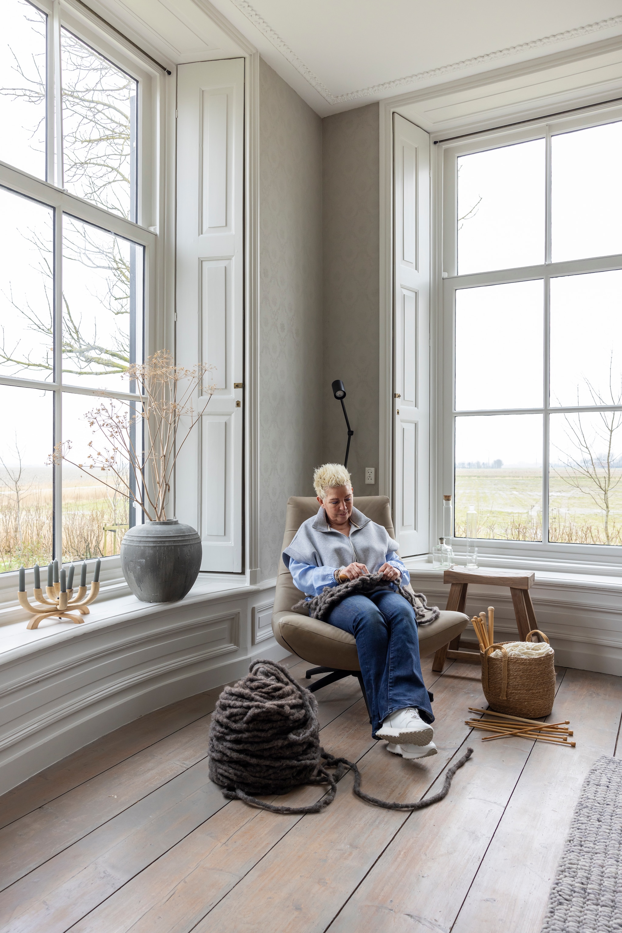 Fauteuil Alle Pilat (winkel is opgeheven). Lamp Ikea. Mand Karwei. Kruk Leen Bakker. Grote bol wol en breipennen WenKR8. vtwonen Landelijk 02-2026 | fotografie Anneke Gambon
