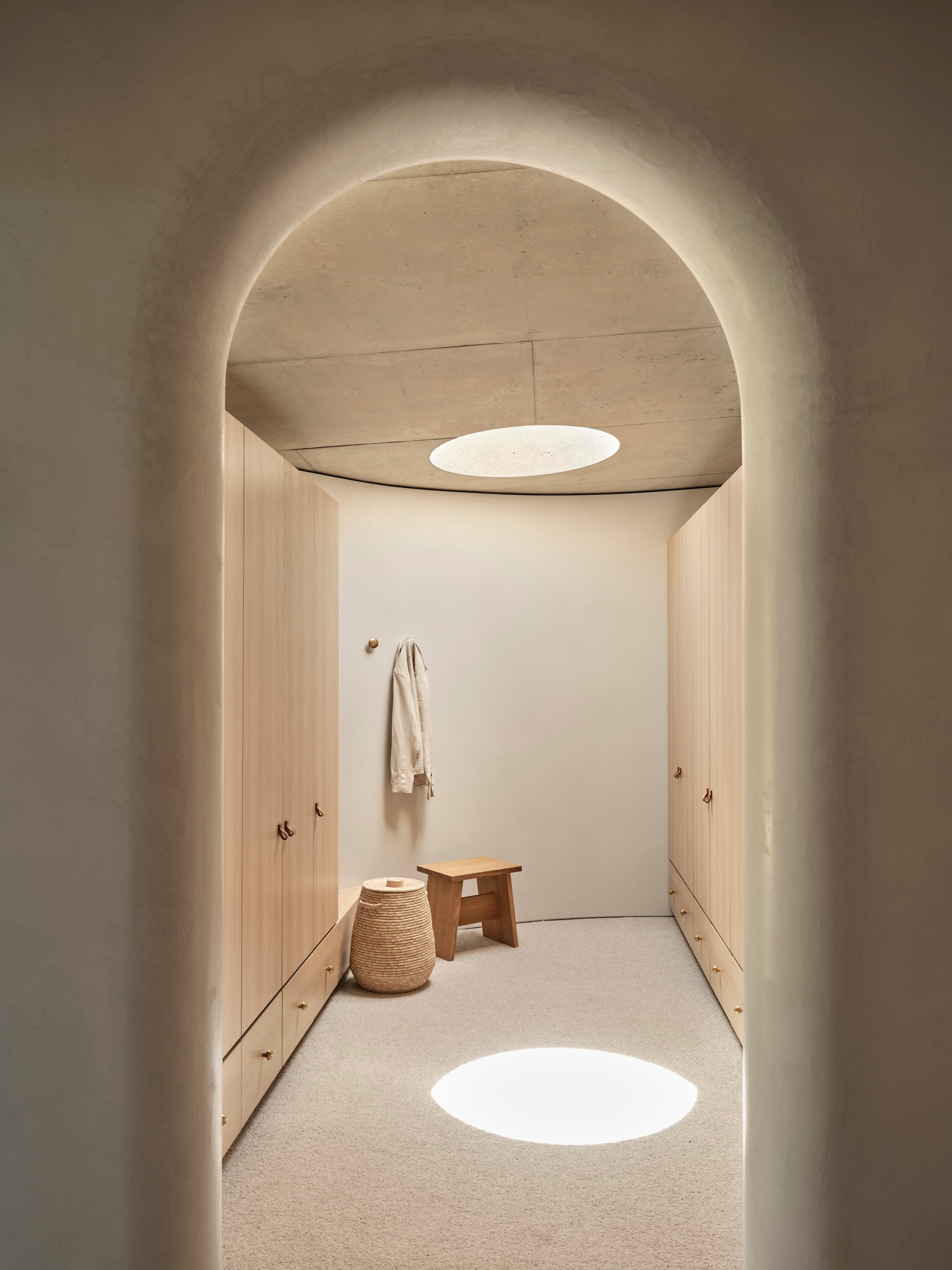 Op maat gemaakte kledingkast Distinct Joinery. Mand The Dharma Door. Eikenhouten kruk E15. vtwonen Design 01-2026 | productie Living Inside | fotografie Lisa Cohen