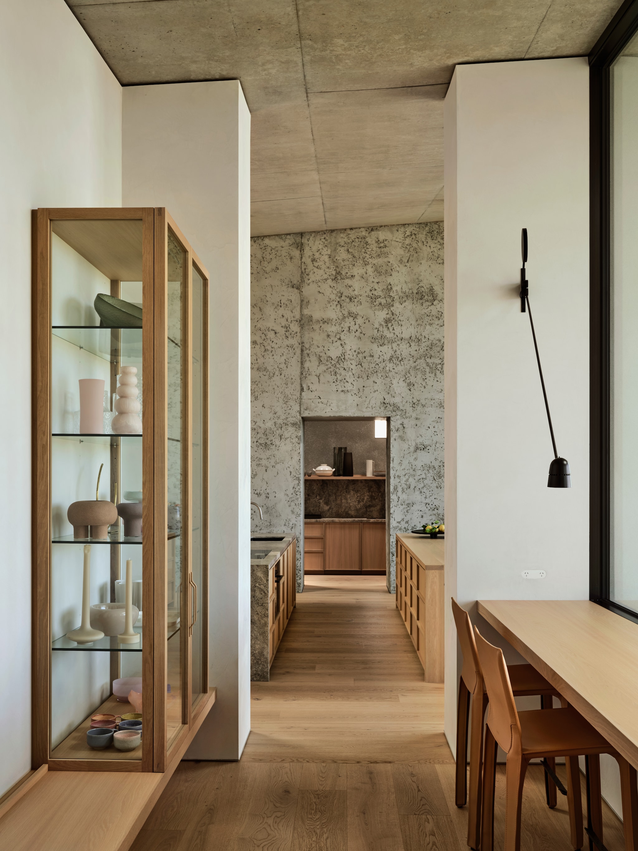 Op maat gemaakte houten kasten, tafel en bank Leeton Pointon Architects. Krukken Mario Bellini voor Cassina. Wandlamp Artemide. vtwonen Design 01-2026 | Productie Living Inside | Fotografie Lisa Cohen