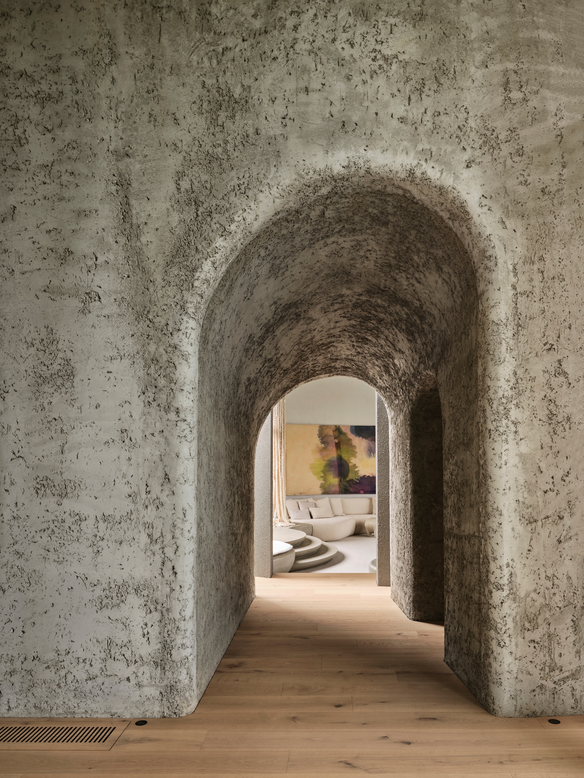 De gang die van de keuken naar de woonkamer leidt met indrukwekkende gebogen betonnen wanden. vtwonen Design 01-2026 | productie Living Inside | fotografie Lisa Cohen