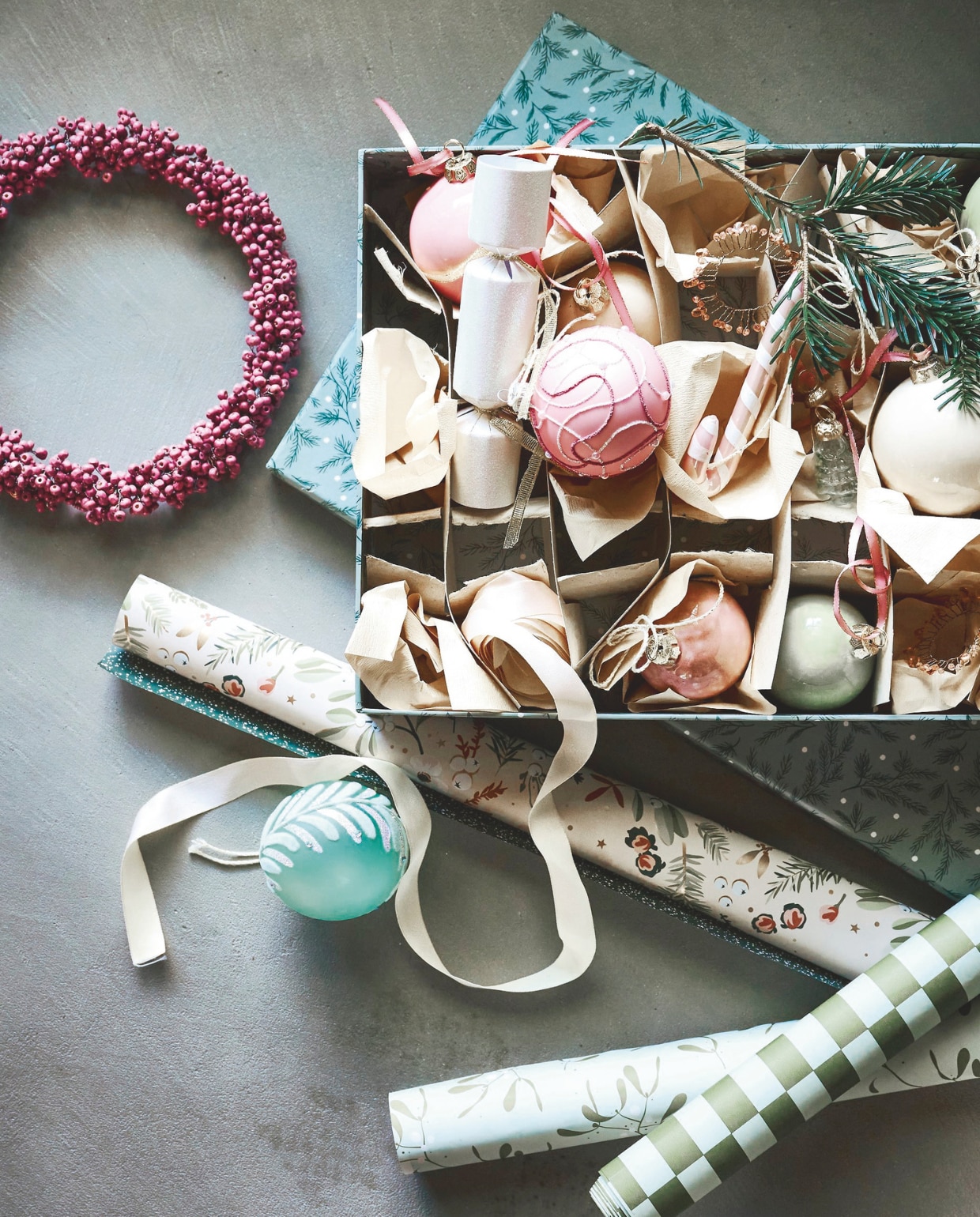 Collectivwarehouse cadeaupapier Comfort & Joy, papier, 300x50 (lxb), set van 5 rollen € 7,95, lint, satijn, lichtroze, 2500 cm (l) € 2,99 (collectivwarehouse.com). Edith Beurskens kerstballen, keramiek, roze, ivoor en mintgroen, 6 cm (Ø) € 47,50, 8 cm (Ø) € 52,50 (edithbeurskens.com). Dagmara kerstbal met details, glas, pastelroze, set van 4 € 23,90, kerstbal Candy Cane, glas, roze, set van 2 € 15,90, kerstbal, glas, mintgroen, set van 4 € 27,90 (shop.vtwonen.nl). Weldaad krans, messing en hout, oudroze, 24 cm (Ø) € 39,95, minikerstboompjes, glas, prijs op aanvraag (weldaad.com). Søstrene Grene geschenkdoos, blauw € 6,68 decoratieve kerstcrackers, papier, wit € 4,52 (sostrenegrene.com). vtwonen 11-2025 | styling Liza Wassenaar | fotografie Sjoerd Eickmans