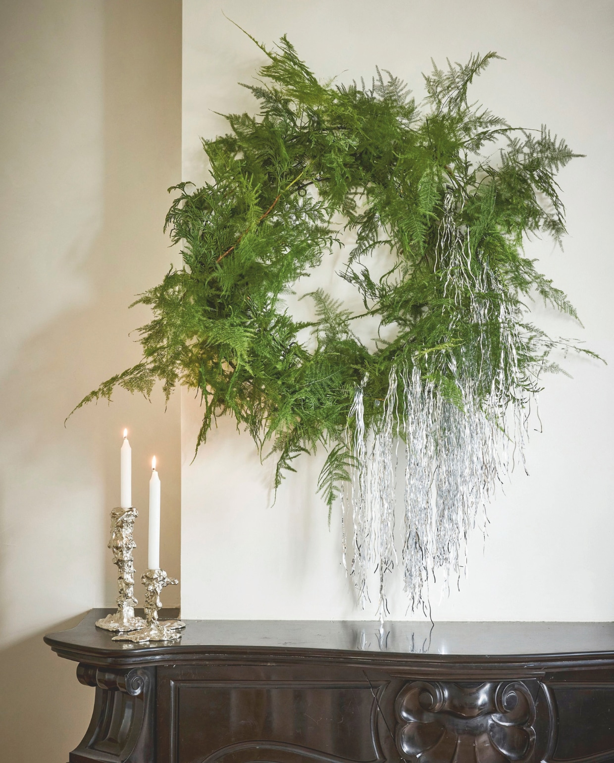 vtwonen decoratiering, metaal, zwart en goud, 60 cm (Ø) € 29,95 (shop.vtwonen.nl). Polspotten kaarshouder Drip, metaal, silver, vanaf € 60,- (polspotten.com). Overig privébezit. vtwonen special Kerstboek 2025 | styling Sanne Ketelaar | fotografie Alexander van Berge