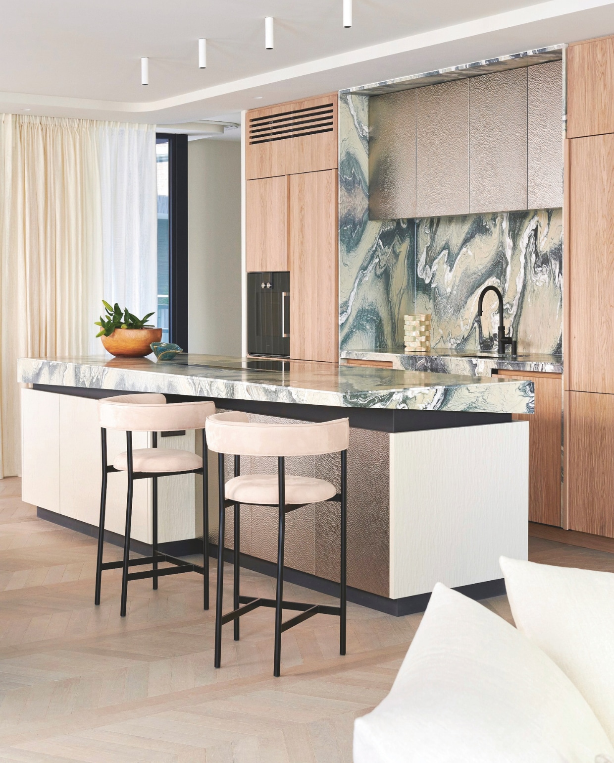 Op maat gemaakte keuken van Framework Studio in kaashout (natuurlijke kleur en gespoten). Details van blauw staal. Hoge kastfronten van geborsteld metaal. Marmeren kookeiland in Cipollino Verde. Verlichting boven kookeiland Kreon. Barkrukken Mobel Copenhagen. Stijlvol wonen 9-2025 | fotografie Kasia Gatkowska