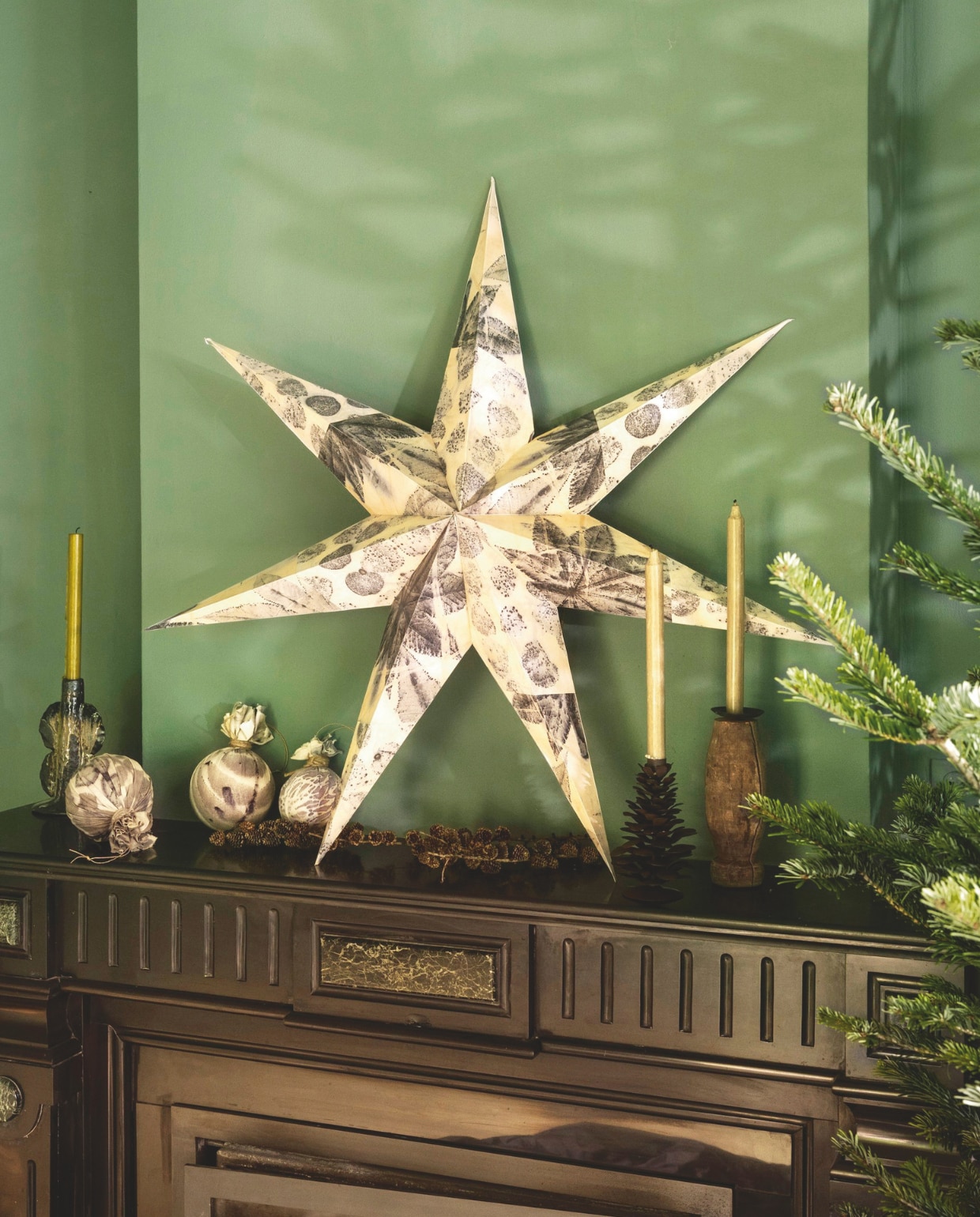 Ambermaakt kerstster gedecoreerd met ecopapier, handgemaakt, prijs op aanvraag, kerstballen, textiel, ecoprint, vanaf € 25,-(ambermaakt.nl). J-Line kandelaar Naga, keramiek, bruin € 30,40 (shop.vtwonen.nl). Madam Stoltz kandelaar, geüpcycled hout, set van 3 € 24,75, kandelaar dennenappel, metaal, bruin € 24,-(deens.nl). vtwonen 11-2025 | styling Marianne Luning | fotografie Stan Koolen