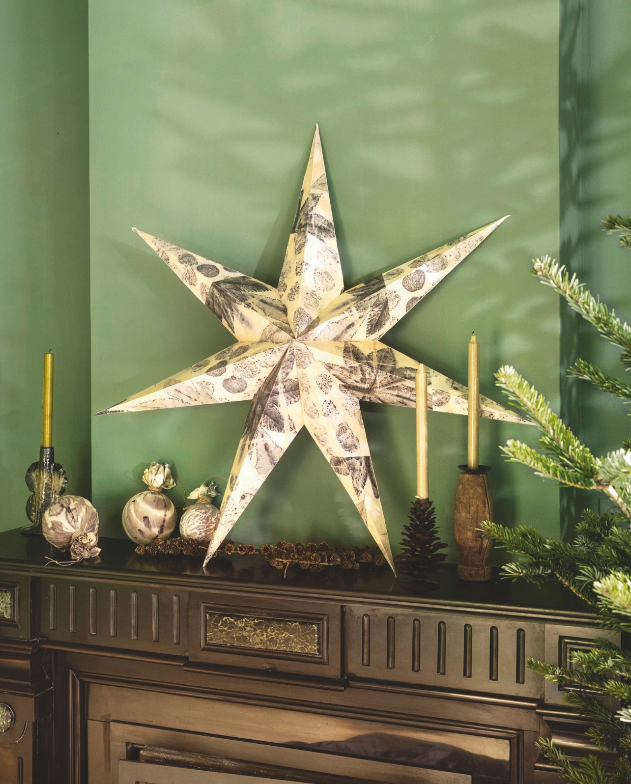 Ambermaakt kerstster gedecoreerd met ecopapier, handgemaakt, prijs op aanvraag, kerstballen, textiel, ecoprint, vanaf € 25,-(ambermaakt.nl). J-Line kandelaar Naga, keramiek, bruin € 30,40 (shop.vtwonen.nl). Madam Stoltz kandelaar, geüpcycled hout, set van 3 € 24,75, kandelaar dennenappel, metaal, bruin € 24,- (deens.nl). vtwonen 11-2025 | styling Marianne Luning | Stan Koolen