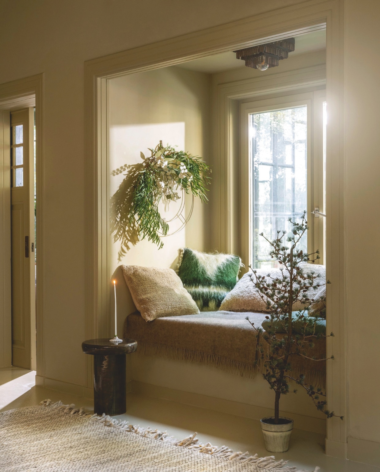 Mr Plant kerstboom, kunststof, € 47,95 (mr-plant.nl). Malagoon Kussens Solid, wol, cocoon beige € 49,95, kussen Triangle, wol, groen € 89,- (malagoon.com). Klippan deken Gotland, wol, pear € 95,95, Dutchbone bijzettafel Mush, mangohout, groen, 35x45 cm (Øxh) € 149,-, Zuiver vloerkleed Frills, wol, beige en geel, 240x170 cm € 469,-, vtwonen kandelaar, keramiek, wit € 25,-, vtwonen decoratiering, metaal, goud 60 cm (Ø) € 29,95 (shop.vtwonen.nl). Jurianne Matter bloemen Eucalyptus, papier, prijs op aanvraag, Field flowers large, pastel, per pakket € 17,50 (juriannematter.nl). Decoflorall adventskaars, wit, set van 12 € 7,45 (decoflorall.nl). vtwonen 11-2025 | styling Marianne Luning | fotografie Stan Koolen