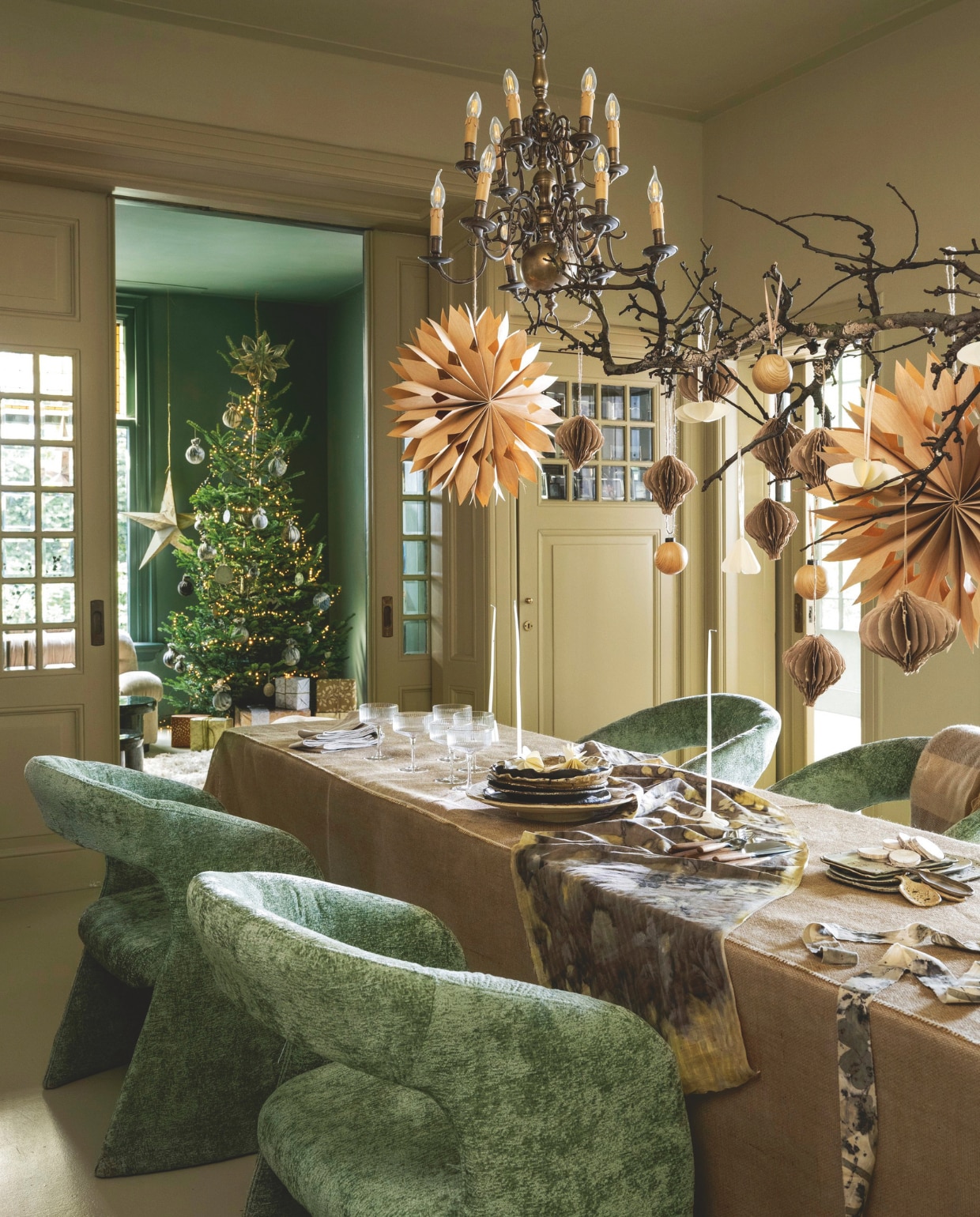 J-Line eettafelstoelen Anise, velours, groen, 65x73x86cm (lxbxh) € 398,-, vtwonen champagneglas, coupe, glas, transparant met gouden rand, set van 4 € 35,-, kandelaars, keramiek € 25,-en € 35,-, My Flowers.shop houtschijven Naturelle, berkenhout, naturel, 250 g € 21,65 (shop.vtwonen.nl). De Boerenbonthal tafelkleed, grof jute, zand, per strekkende meter € 12,50 (boerenbonthal.nl). Ambermaakt tafelloper, ecoprint katoen, gemaakt tijdens ecoprint workshop, per dag € 169,- (ambermaakt.nl). Dille & Kamille servet Gots, biokatoen, kiezel € 2,95, bestek, hout, bruin € 6,95 (dille-kamille.nl). @carolinelovesceramics borden, keramiek € 30,-, schalen, keramiek, vanaf € 20,-, opscheplepels, keramiek, prijs op aanvraag (@carolinelovesceramics). Decoflorall bloemsteekkaars, wit, set van 12 € 8,99 (decoflorall.nl). Madam Stoltz ornament Honingraat, gerecycled papier, greige, set van 2 € 15,25, Deens kerstster, bamboe € 17,25 (deens.nl). Blomus ornamenten Kazary, papier, gevouwen, wit, set van 4 € 24,95, kerstbal Kiseky, houtlook, beige, set van 4 € 34,95 (blomus.com). Overig privébezit. vtwonen 11-2025 | styling Marianne Luning | Stan Koolen