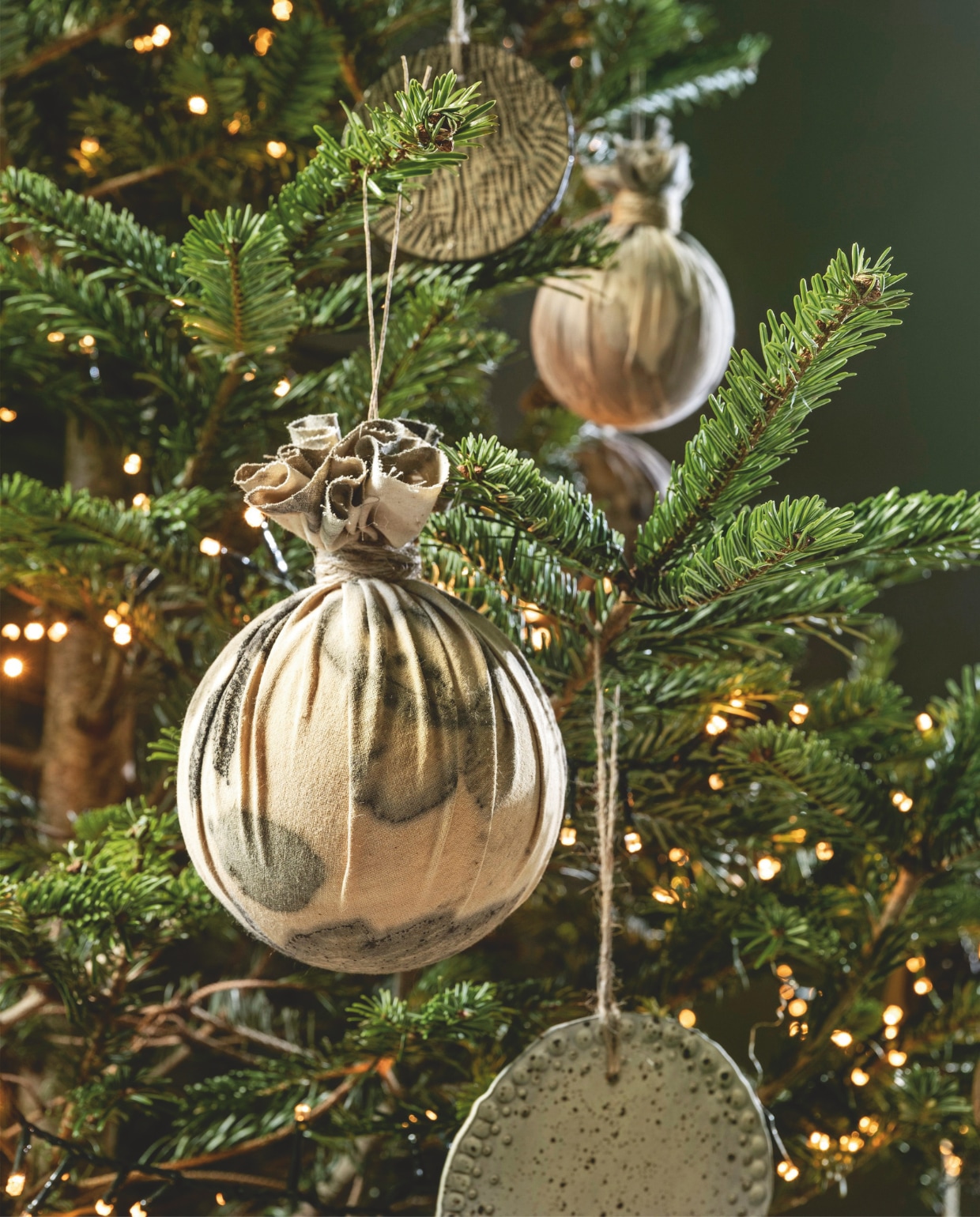 Ambermaakt kerstballen, textiel, ecoprint € 25,- (ambermaakt.nl). @carolinelovesceramics kerstballen plat, keramiek, naturel, vanaf € 6,- (@carolinelovesceramics). vtwonen 11-2025 | styling Marianne Luning | Stan Koolen