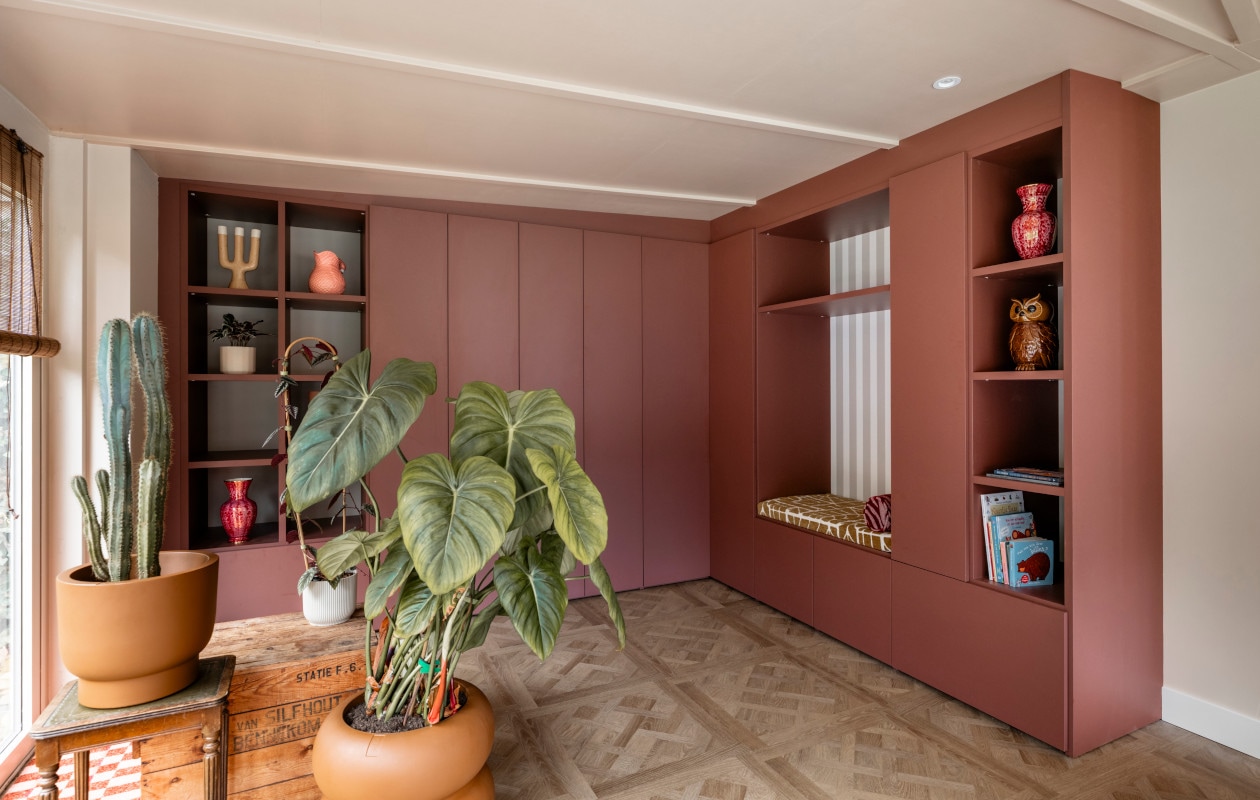De maatwerk kast van Aanhuis.nl met open vakken, deuren, planken, verlichting en een speels zitje.