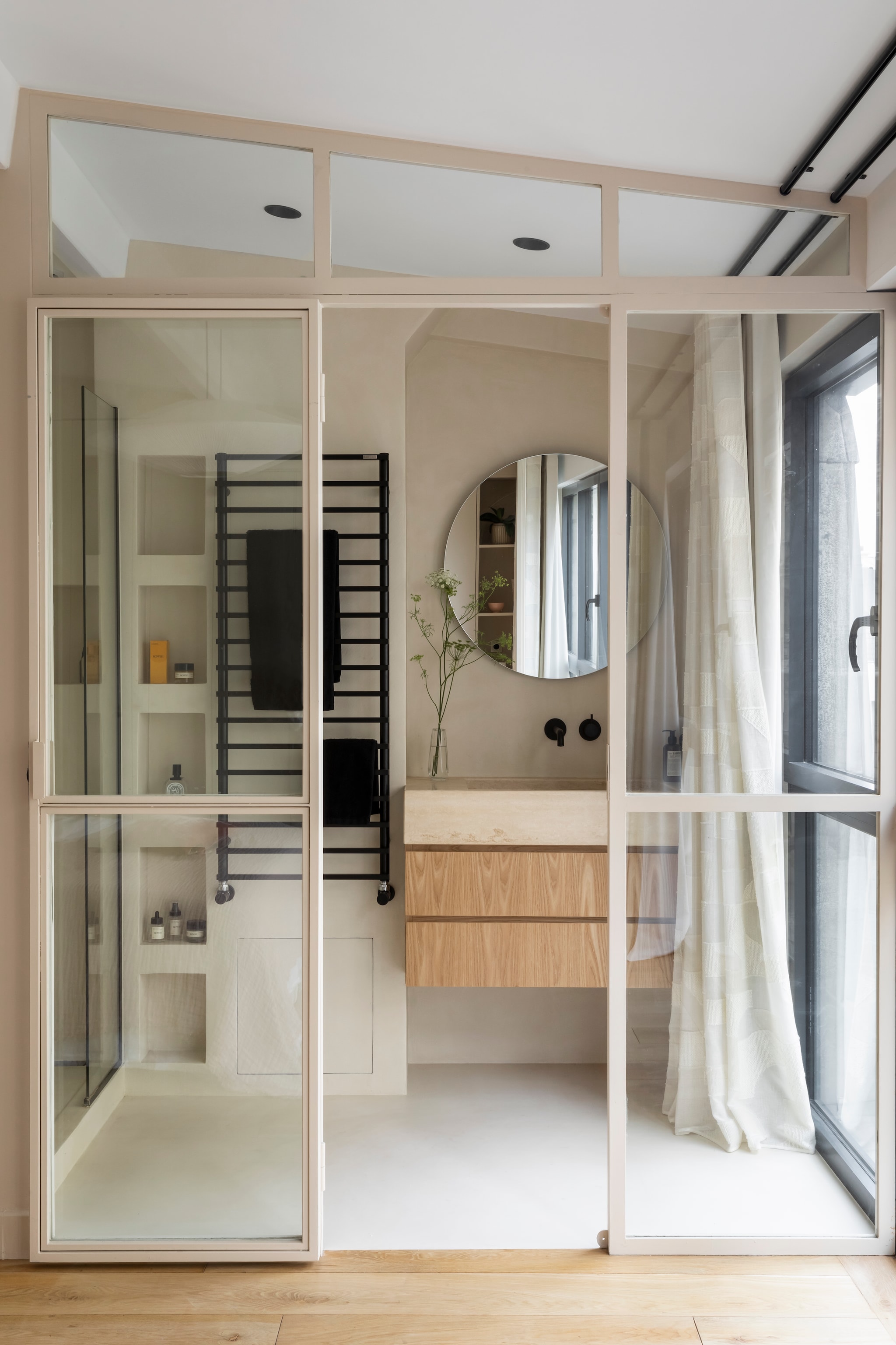 Badmeubel maatwerk. Kranen Hotbath. Handdoekradiator Tubes. Gordijnen Sophie la tapissière. Vloer en muren Propose Paris. Houten vloer La Parqueterie Nouvelle.
 vtwonen 02-2026 | styling Camille Hermand | fotografie Pauline Le Goff | productie AC Scoffoni