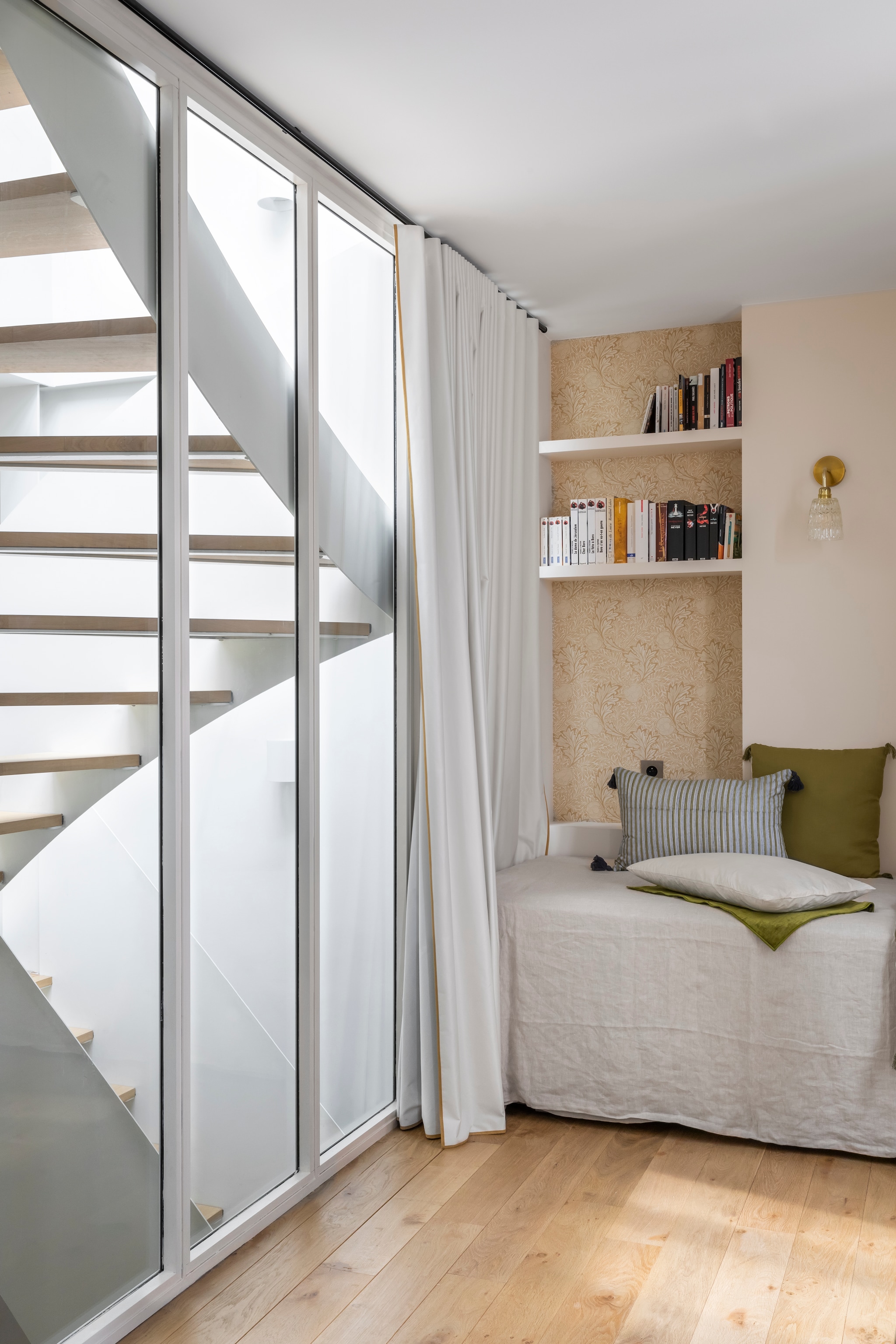 Behang Honey Gold van Morris & Co. Gordijnen Sophie la tapissière. Opklapbed Conran Shop. Muurkleur Dimity van Farrow & Ball. vtwonen 02-2026 | styling Camille Hermand | fotografie Pauline Le Goff | productie AC Scoffoni