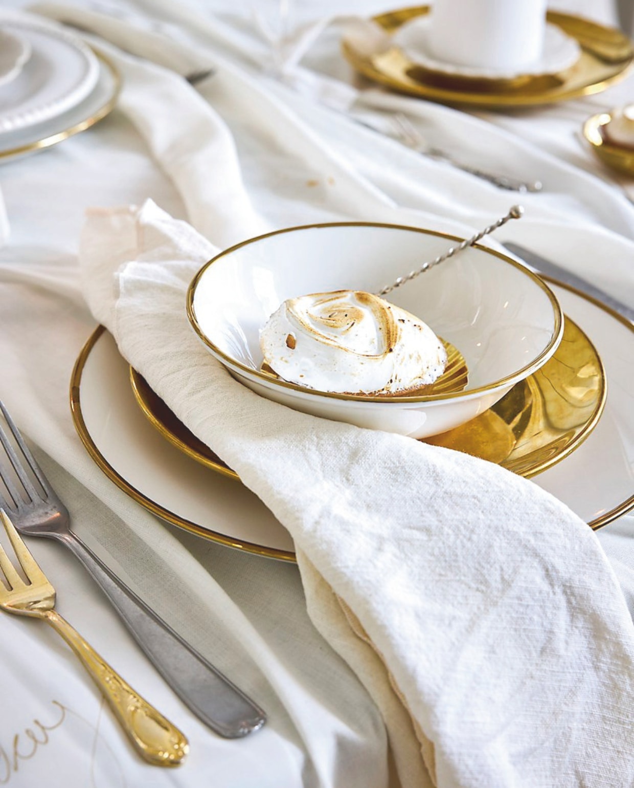 vtwonen kommen, porselein, wit-goud 18 cm (Ø), set van 4 € 39,-, borden, porselein, wit-goud, 25,5 cm (Ø), set van 2 € 25,-, borden, porselein, goud, 12 cm (Ø), set van 4 € 24,95, servetten, katoen/linnen, wit, 40x40 cm, set van 2 € 10,95, bestekset, matzwart, 18-delig € 89,- (shop.vtwonen.nl). Simon Meijssen citroenmerengue gebakje (simonmeijssen.nl). Overig privébezit. Salt & Pepper taartplateau Cameo, aardewerk, beige, 33,5x12 (Øxh) € 37,90 (shop.vtwonen.nl). Sp Collection bestekset Terno, staal, goud, 16-delig € 82,90 (shop.vtwonen.nl). vtwonen champagneglas, coupe, geribbeld glas met gouden rand, 300 ml, set van 4 € 35,-. (shop.vtwonen.nl). vtwonen kerstspecial 2025 | styling Sanne Ketelaar | fotografie Alexander van Berge, Stan Koolen