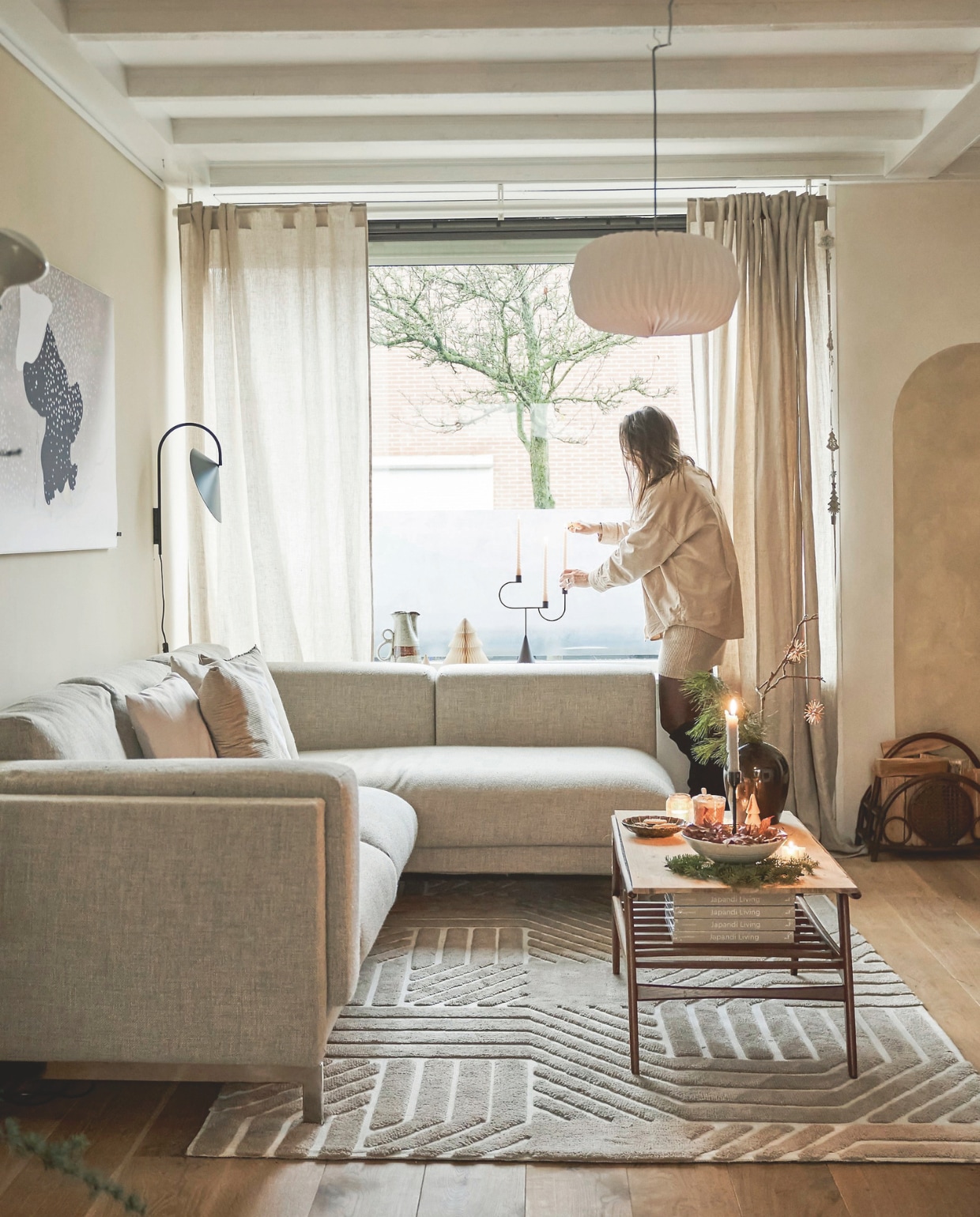 Bank Ikea, Kussens H&m Home en Sissy-Boy. Salontafel tweedehands. Vloerkleed Loods 5. Lampenkap Jysk. Wandlamp en kandelaar Ferm Living. Kunstwerk Dwarrelende Sneeuw van Kamisaka Sekka. Vaas kringloop. Muurkleur Morgenfrisk van betonlook.nl x Japandi by Laila. vtwonen 11-2025 | styling Kamer465 | fotografie Muk van Lil  | tekstbewerking Britte Kramer