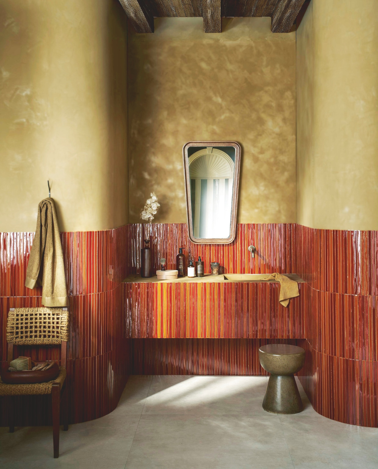 Op de wand: vtwonen wandtegel Rib, honey crackle glans, 13,4x45 cm, per stuk € 9,95. Op de vloer: vtwonen vloer- en wandtegel Noble, sand, 100x100 cm, per m² € 76,-. M.m.v. bestwelhip.nl (stoel), lauthentique.nl (kalkverf Oker 153), zarahome.com (spiegel, wandhaak, badlakens, badproducten), hkliving.com (kruk, houten schaal). Overig privébezit. vtwonen 08-2025 | productie Tanja Saarberg | styling Cleo Scheulderman | fotografie Jeroen van der Spek | assistentie Aylin Citanak