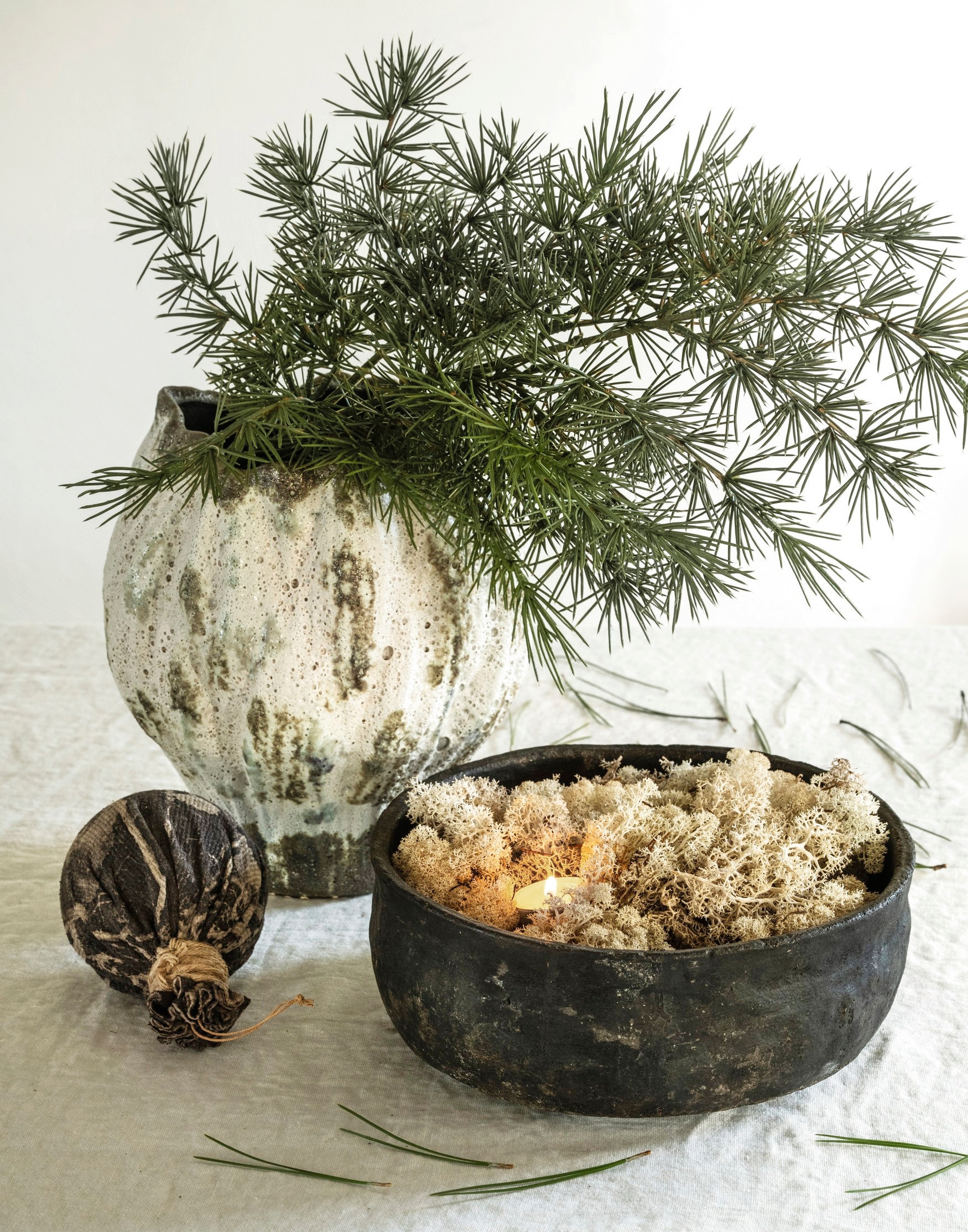 Vincent Van Duysen tafelkleed, linnen, wit, 310x257 cm (lxb) € 229,- (zarahome.com). Aura Peeperkorn schaal, aardewerk, bruin € 89,95 (aurapeeperkorn.nl). Amber maakt kerstbal ecoprint, textiel, naturel vanaf € 25,- (ambermaakt.nl). My Flowers.shop rendiermos, groen, per bak € 6,99 (shop.vtwonen.nl). Nordal vaas Henry, keramiek, naturel € 90,91 (nordal.com). vtwonen landelijk 11-2025 | styling Marianne Luning | fotografie Stan Koolen