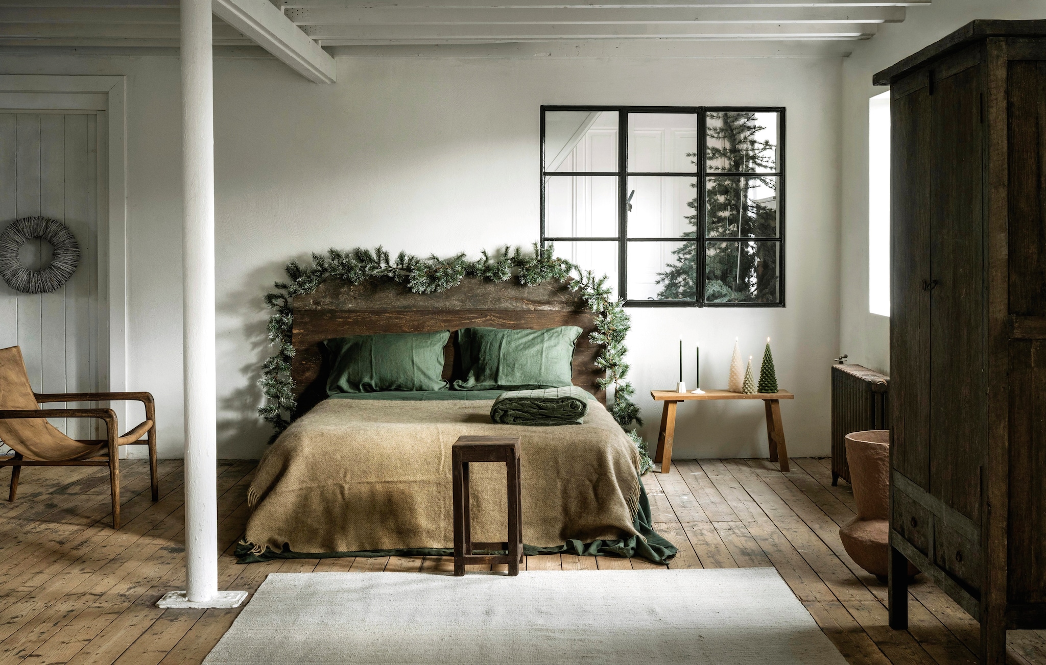 Het Kabinet fauteuil, teak met buffelleer, bruin, 67x74x80 cm (bxdxh) € 839,- (hetkabinet.nl). Aura Peeperkorn kast, oud teak, 112x50x190 cm (bxdxh) € 1695,-, hoofdbord, oud teak, 180x100 cm (bxh) € 1195,-, kruk, hout, bruin € 99,95,  (aurapeeperkorn.nl). Loods 5 vloerkleed Nomad sand, wol, 300x200 cm (lxb) € 1495,- (loods5.nl). Rustik Lys kerstboomkaarsen, waxine, groen vanaf € 9,95, kaarsen, groen en witgroen met hulsttakje, set van 4, prijs op aanvraag(rustiklys.nl). My Flowers.shop kerstkrans Mactan, gras, naturel€ 49,59, soortgelijke guirlande Triumph Tree guirlande Colorado, pvc, frosted green, 180 cm € 28,95 Mica bank, hout, bruin € 114,95, vtwonen kandelaars, keramiek, wit, set van 2 € 14,95, J-line pot Archaic, papier-maché, bruin € 161,50, Klippan deken Gotland, wol, beige € 95,95 (shop.vtwonen.nl). Marc O’Polo sprei Julia, fluweel, vanaf € 219,95, beddengoed Valka, linnen, diepgroen, vanaf€ 169,95 (essenzahome.nl). Overig privébezit. vtwonen landelijk 11-2025 | styling Marianne Luning | fotografie Stan Koolen