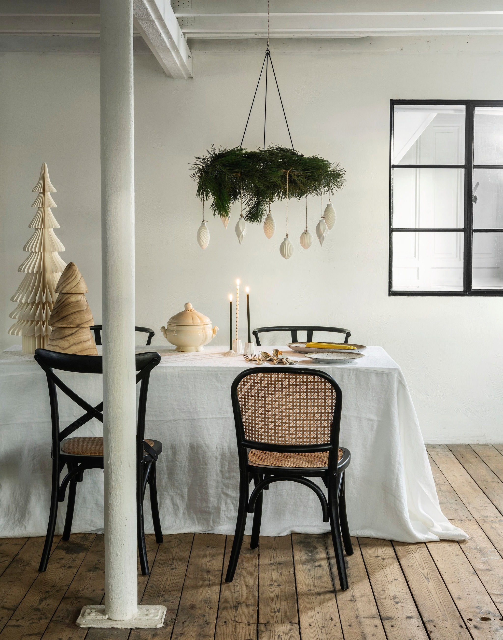 vtwonen decoratiering, metaal, zwart € 29,95, kandelaars, keramiek, wit, set van 2 € 14,95, kerstornament Waffle, porselein, wit € 9,95, kerstornamenten Diamond, porselein, wit, set van 4 € 29,- en kerstornament Stripes, porselein, wit € 8,95 (shop.vtwonen.nl). Rustik Lys kaarsen, groen en witgroen met hulsttakje, set van 4, prijs op aanvraag (rustiklys.nl). Vincent Van Duysen tafelkleed, linnen, wit 310x257 cm (lxb) € 229,- (zarahome.com). Madam Stoltz eetkamerstoel, hout, zwart € 241,25, kerstboom, hout, bruin € 31,-, kerstboom, papier, wit € 69,- (deens.nl). Nordal eetkamerstoelen Wicky, hout en rotan, zwart-naturel € 322,- (nordal.nl). Het Kabinet eetkamerstoelen, hout en abaca, zwart-naturel € 349,- (hetkabinet.nl). Zilverwerk, serviesgoed en soepterrine privébezit. vtwonen landelijk 11-2025 | styling Marianne Luning | fotografie Stan Koolen