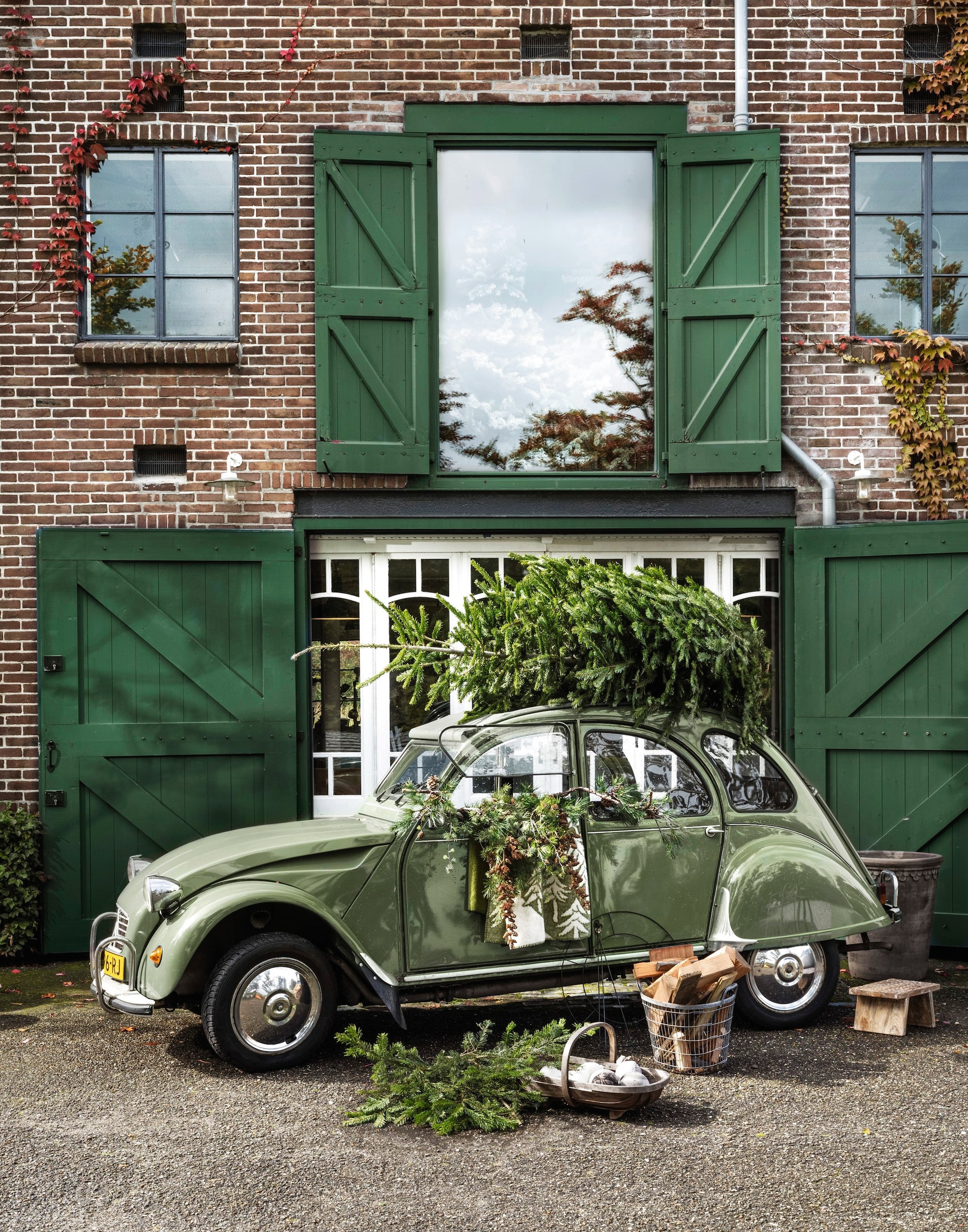 Raw materials kruk Chiseled top, hout, naturel € 55,95, vtwonen kerstornament Waffle, porselein, wit € 9,95, kerstornament Diamond, porselein, wit € 8,95, kerstornament Stripes, porselein, wit € 8,95 en decoratiering, ijzer, zwart € 29,95, Klippan deken House in the forest, wol, groen € 140,95 (shop.vtwonen.nl). Amber Maakt kerstballen ecoprint, textiel, naturel vanaf € 25,- (ambermaakt.nl).  Mister plant divers kerstgroen, tussen € 25,- en € 52,50 (deens.nl). Extra Vert mand, ijzer, grijs € 65,-, Bergs Potter pot, aardewerk, bruin € 675,- (extravert.nl). Plukmand privébezit. Cadeauverpakking en labels: zie pagina 186 in dit nummer voor gratis prints. vtwonen landelijk 11-2025 | styling Marianne Luning | fotografie Stan Koolen