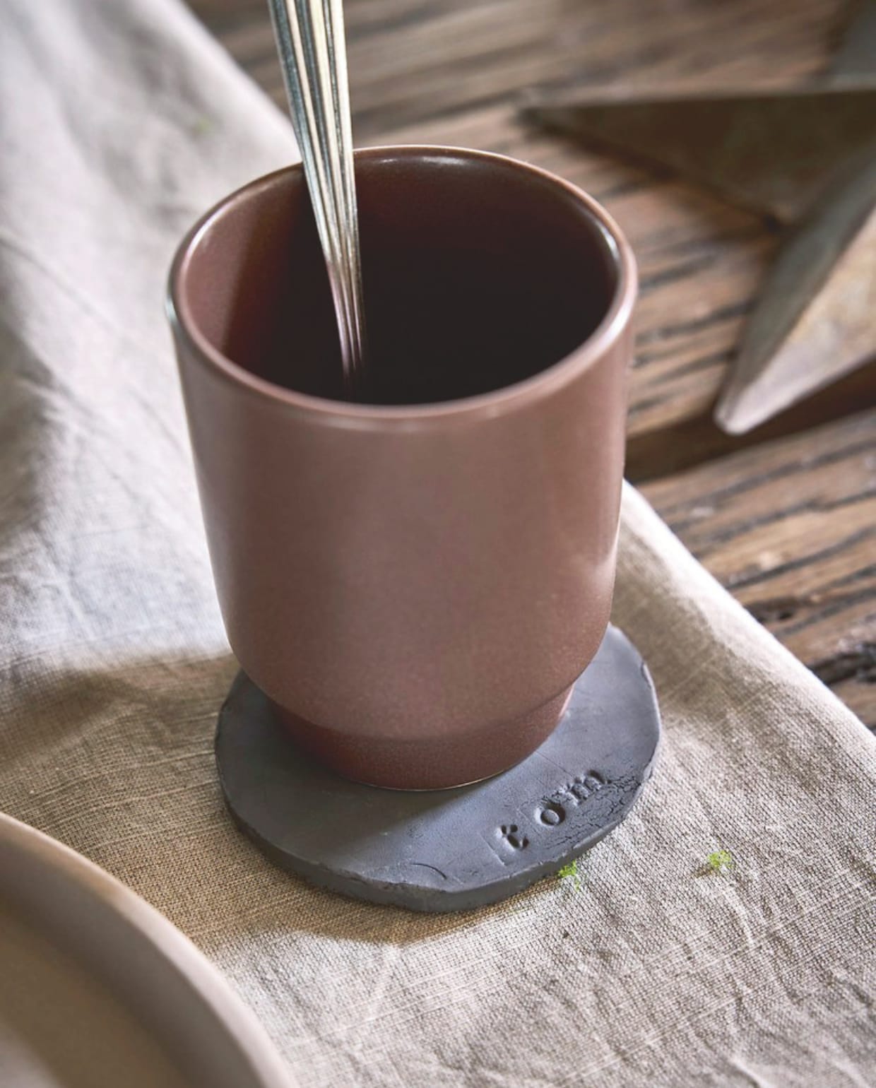 vtwonen mok, keramiek, chocoladebruin, 250 ml, set van 4 € 29,95, tafelkleed, XXX, naturel, 150x250 cm € 79,95 (shop.vtwonen.nl).  Zara Home bestekset, staal, 4-delig € 19,99 (zarahome.com). vtwonen landelijk 11-2025 | styling Sanne Ketelaar | fotografie Alexander van Berge