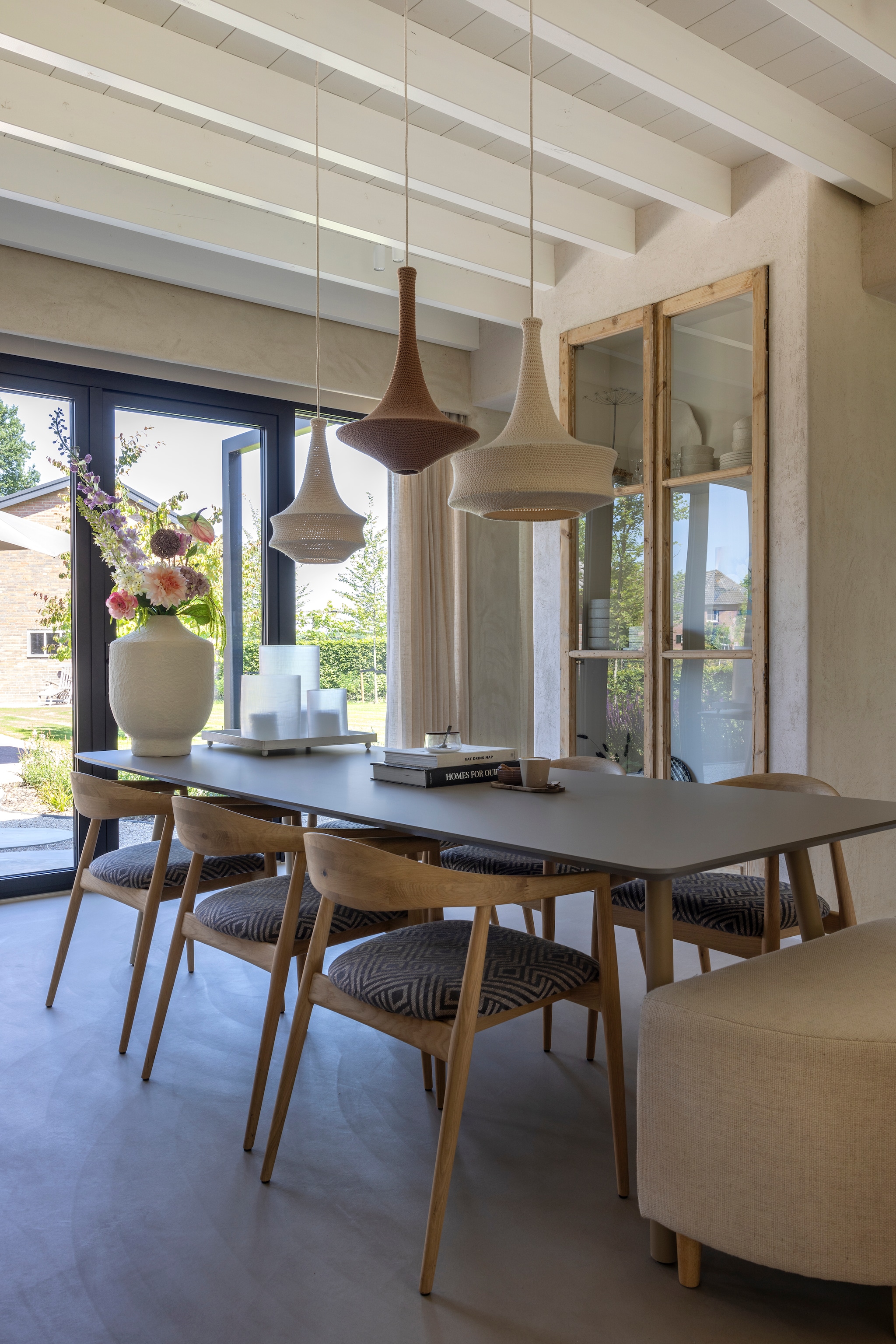 Tafel Cartel Living. Stoelen Bxb Interior. Poef Mengede. Hanglampen gehaakt door een tante van Yoni. Vaas Zara Home. Boeket Rhodé Flowers. Houten deuren Empire Best. vtwonen Landelijk 03-2026 | fotografie Anneke Gambon