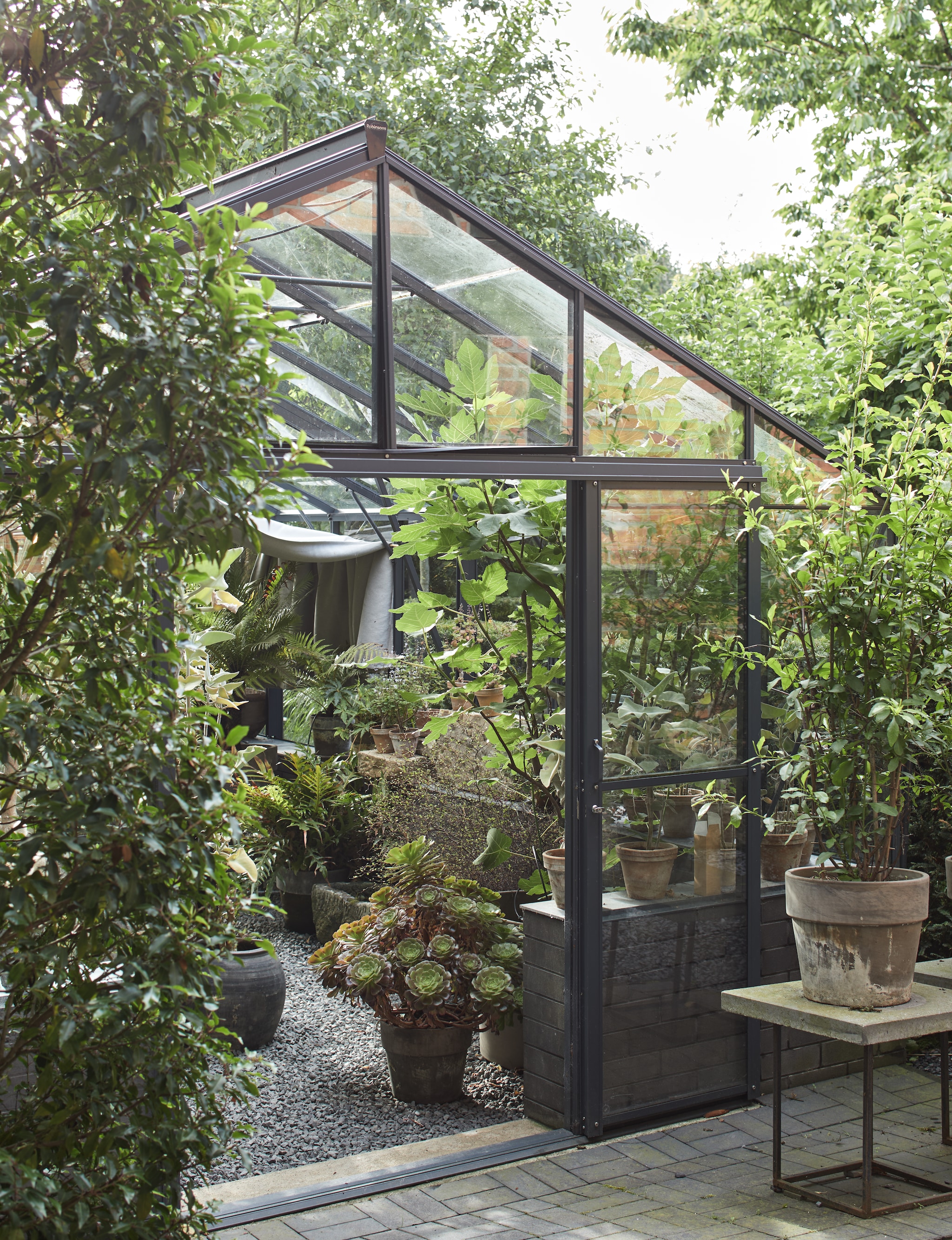 Kas Gewächshausplaza. Meubels in de kas zelf gemaakt. Lampen en potten van vlooienmarkten. vtwonen Landelijk 03-2026 | fotografie Peter Fehrentz | productie Living Inside