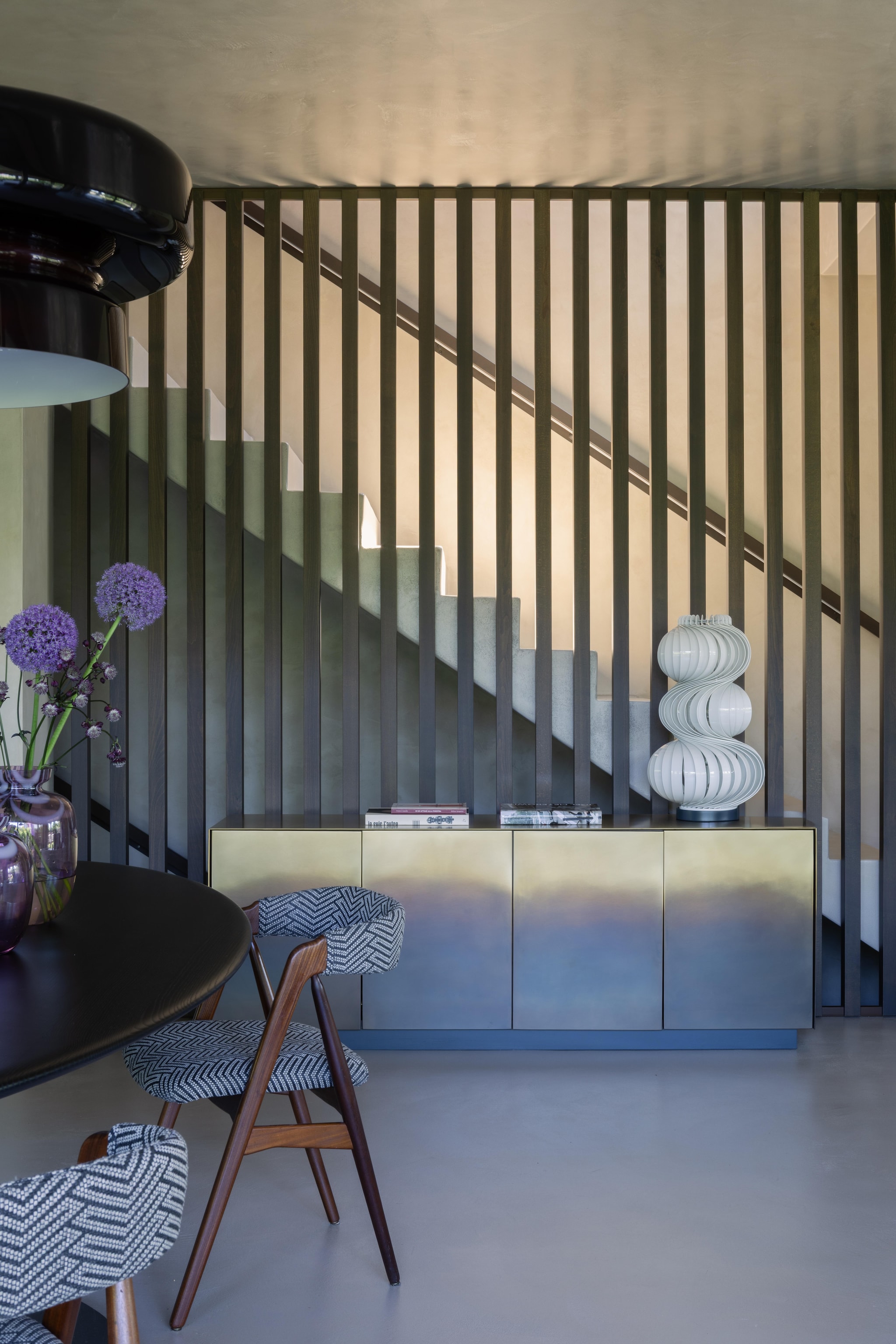 Trap met verticale houten latten van Dekodecking. Dressoir De Castelli. Tafellamp Medusa van Valenti. Deense vintage stoelen, stof Misia Paris. Hanglamp Bohemia van Marset. vtwonen Design 02-2026 | fotografie Monica Spezia | productie Living Inside