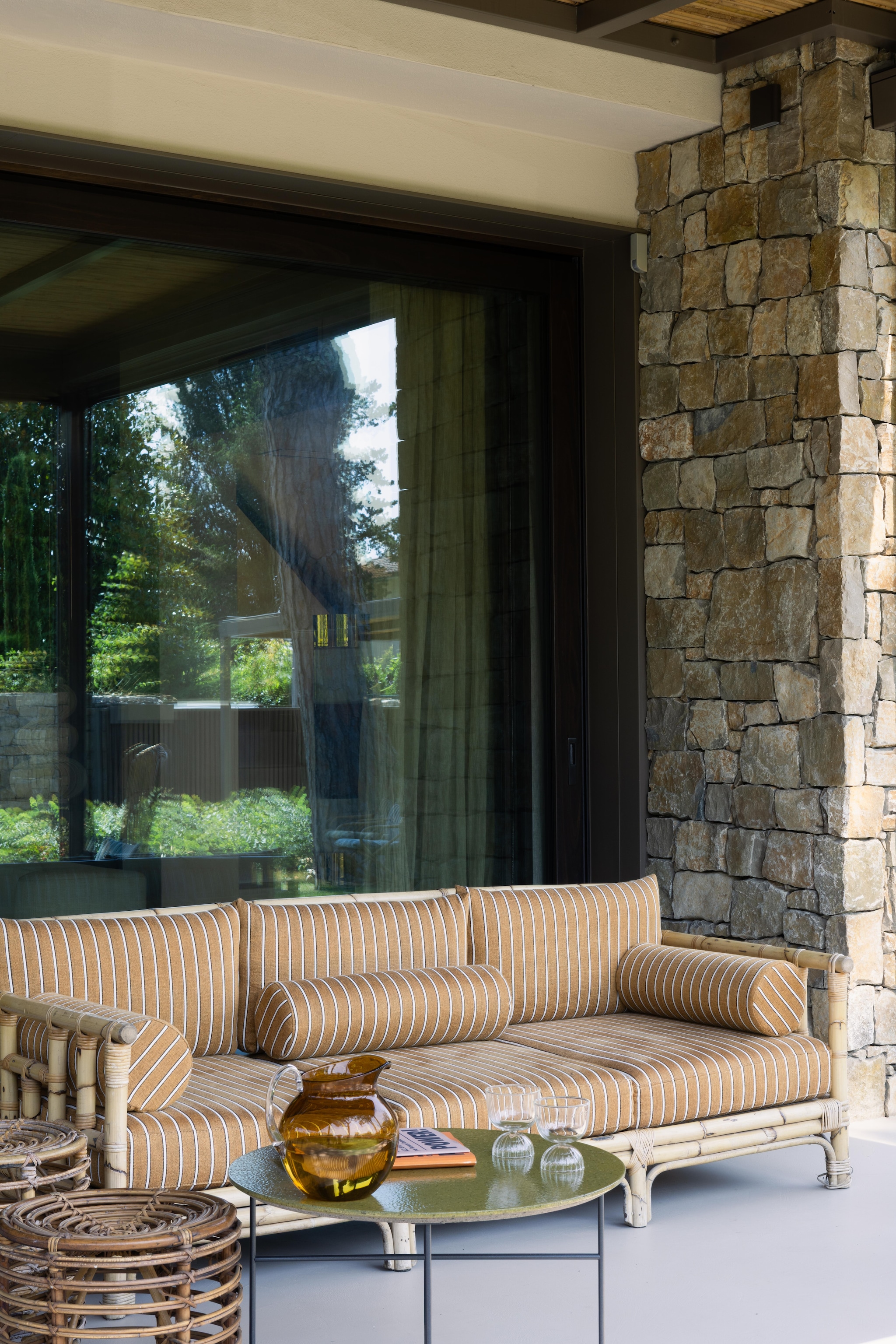 Bamboebank Vivai del Sud. Kussens Fischbacher 1819, stof Capri Collection. Vintage bamboe-bijzettafels. Koffietafel DePadova. Gordijnen van linnen gaasstof. vtwonen Design 02-2026 | fotografie Monica Spezia | productie Living Inside