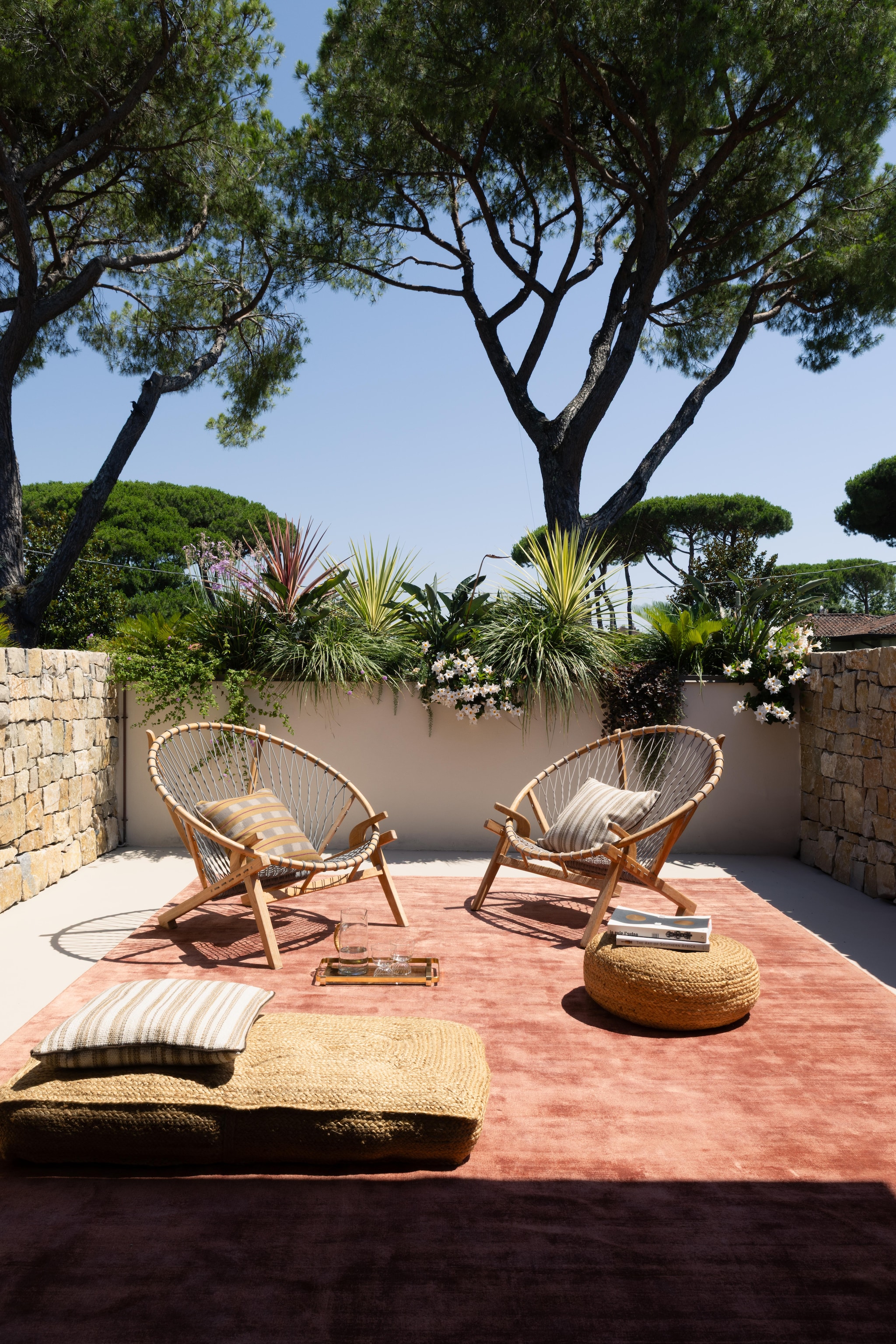 Vloerkleed Galleria Boralevi. Vintage stoelen en etnische poefs door de bewoners meegebracht van reizen. Kussens Manifattura Forasassi. vtwonen Design 02-2026 | Fotografie Monica Spezia | Productie Living Inside