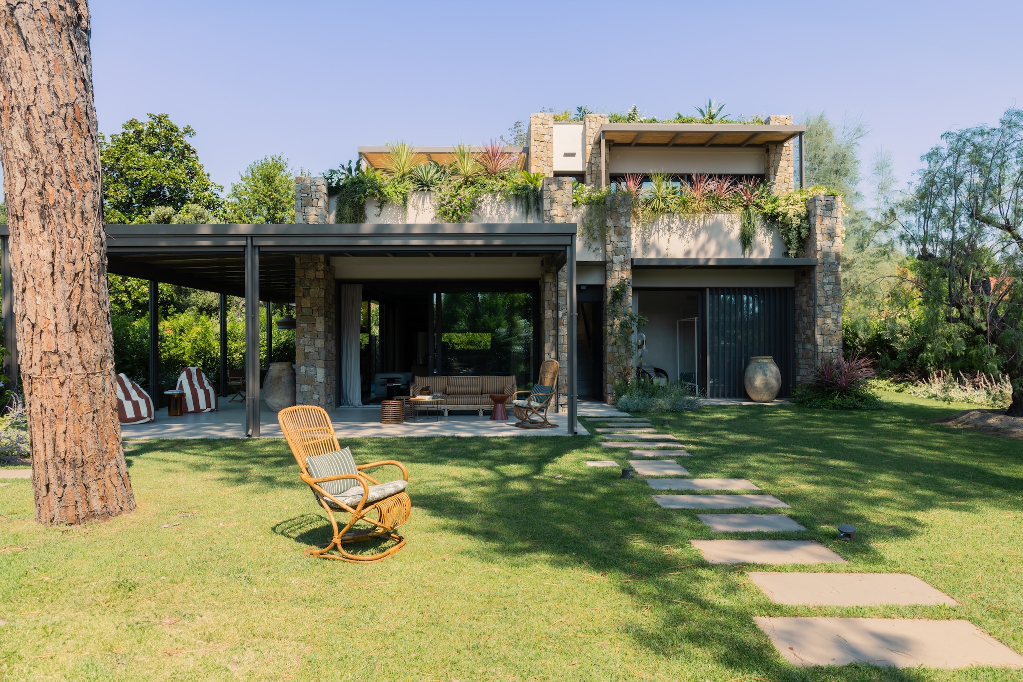 Vintage bamboestoel Tito Agnoli. Kussens Fischbacher 1819, stof Capri Collection. Zitzakken maatwerk, stof Decortex. Soortgelijke zitzakken In The Mood Collection. Transparante bijzettafel Soda van Miniforms. Bamboebank Vivai del Sud. vtwonen Design 02-2026 | fotografie Monica Spezia | productie Living Inside