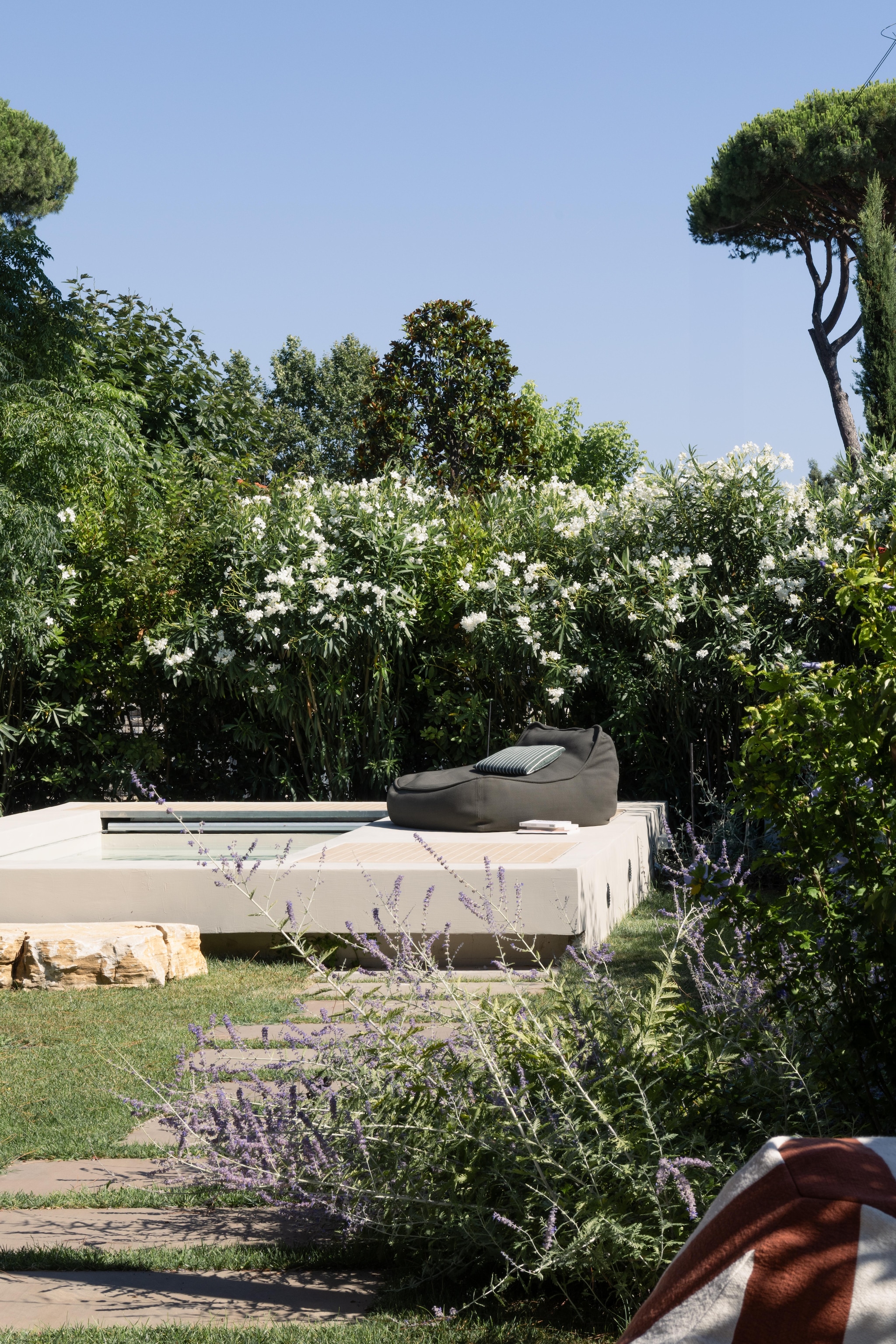 Zwembad van resin en hout. Fauteuil Float van Paola Lenti. Kussen Fischbacher 1819, stof Capri Collection. vtwonen Design 02-2026 | Fotografie Monica Spezia | Productie Living Inside