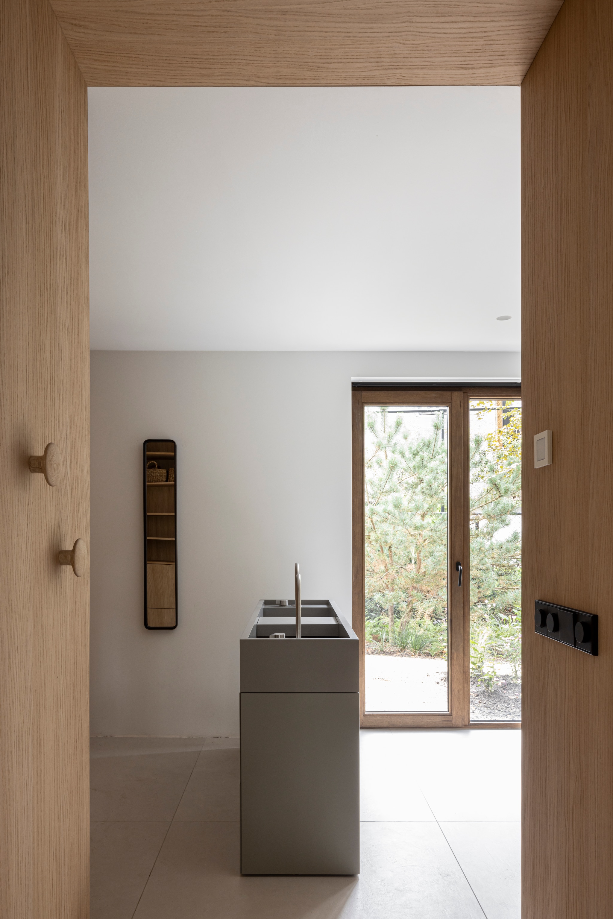 Wastafelmeubel en kraan Cocoon. Wandknoppen Muuto. Spiegel merkloos. Vloertegels Blend Chalk White van Piet Boon. vtwonen Design 02-2026 | fotografie Tim Van de Velde